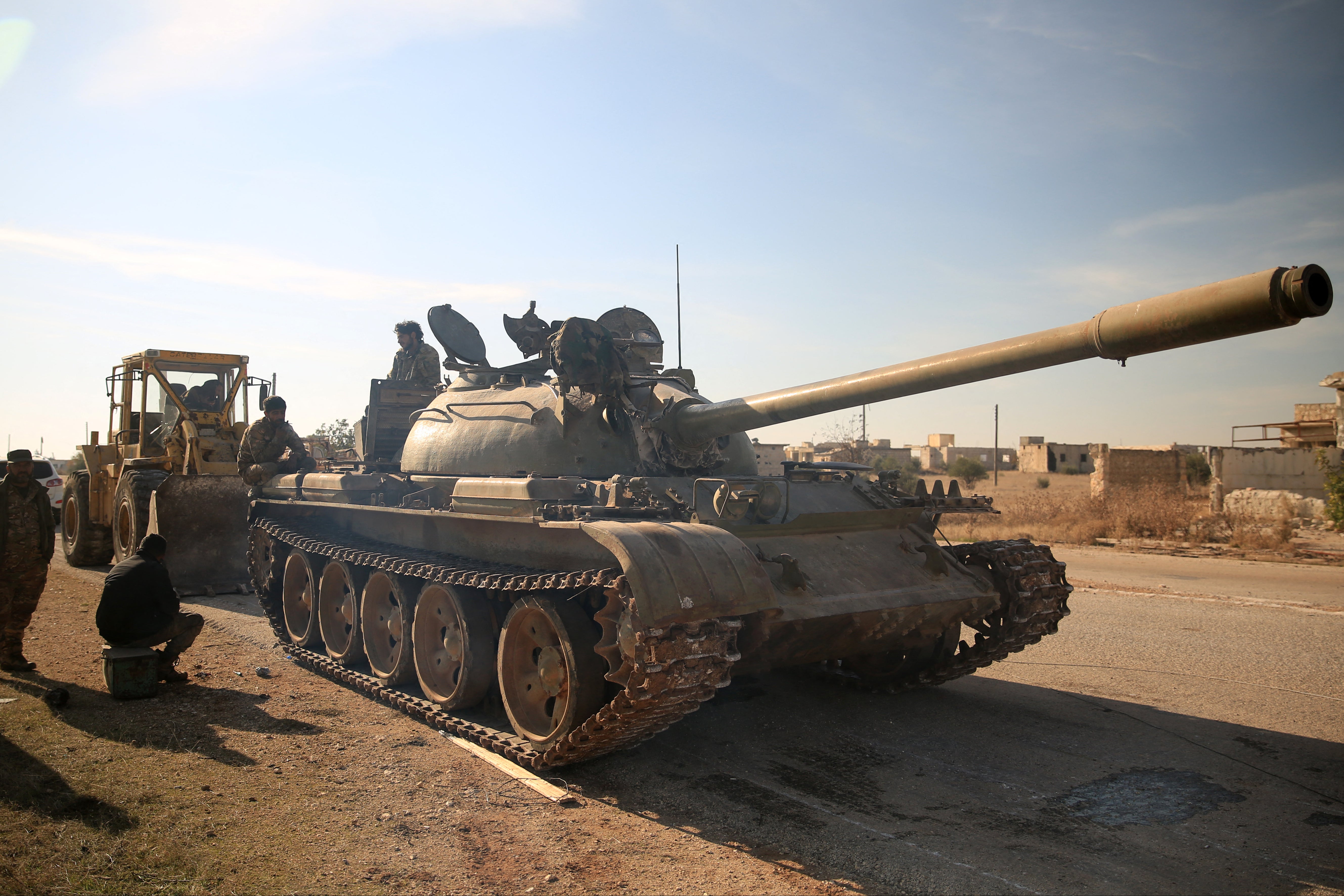 Anti-government fighters inspect an abandoned tank in northern Syria