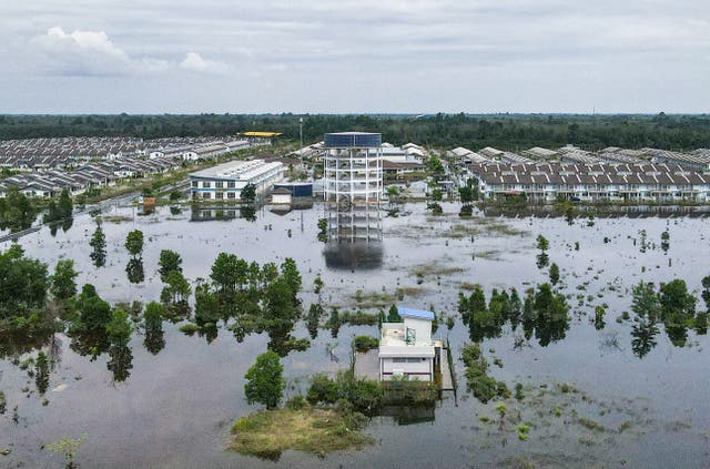 <p>An aerial view shows houses surrounded by floodwaters after heavy rain in Pasir Mas, Malaysia, on 3 December 2024</p>