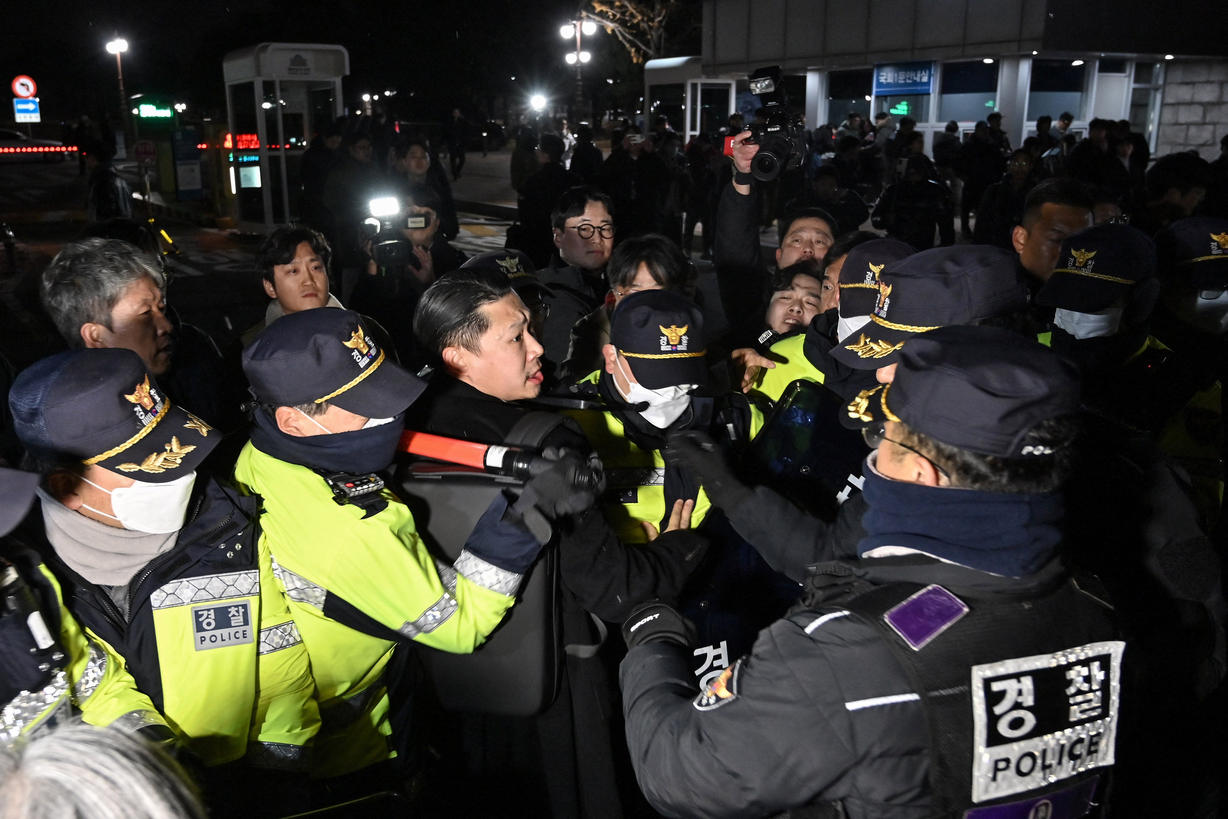 Police hold back crowds outside the National Assembly