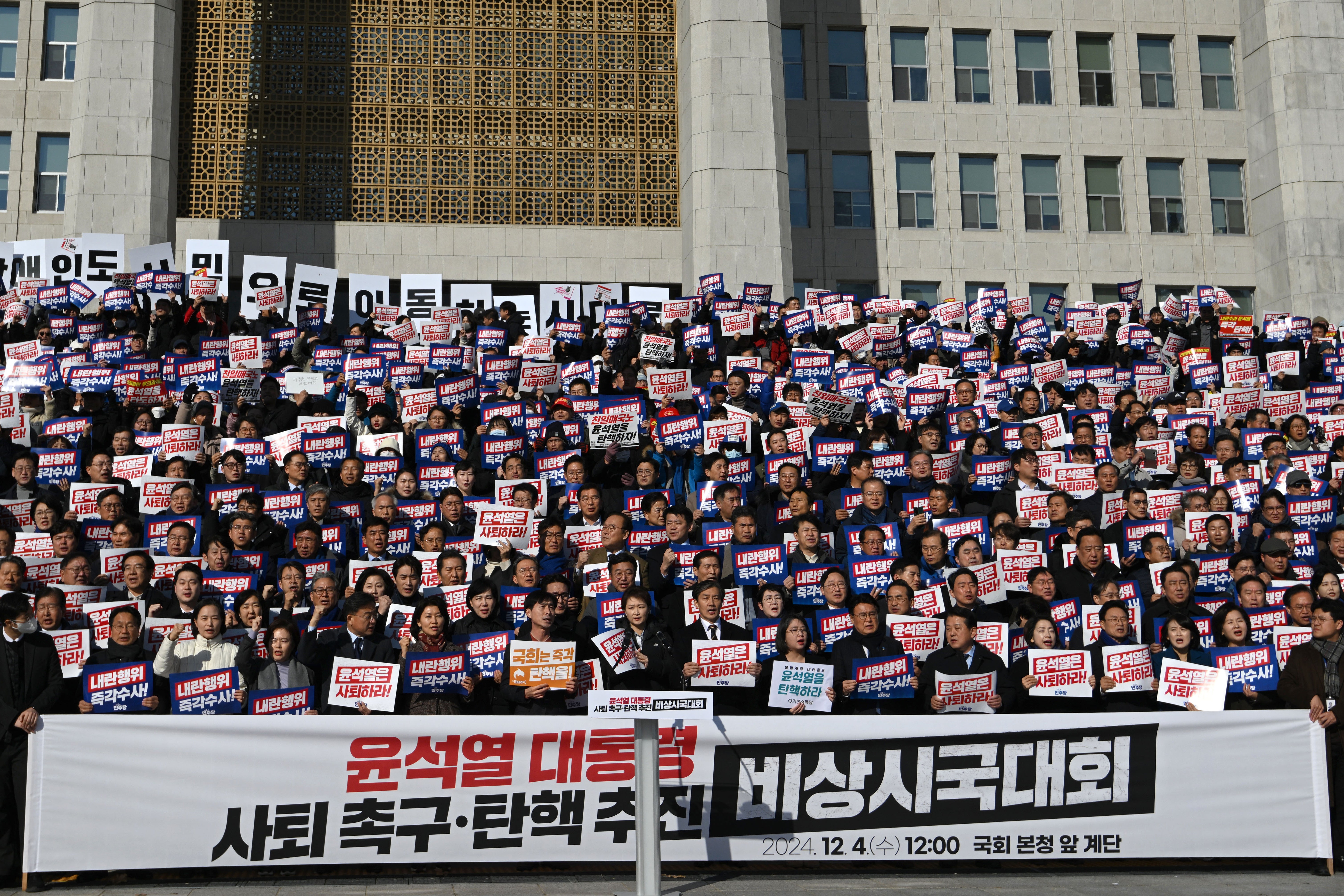 Lawmakers and South Korea’s main opposition Democratic Party members hold placards reading ‘Yoon Suk Yeol should resign!’ during a rally against President Yoon Suk Yeol at the National Assembly in Seoul on December 4, 2024, after martial law was lifted in South Korea. Yoon faced demands to resign on December 4 after his short-lived attempt to impose martial law was voted down by lawmakers and brought thousands of protesters to the streets