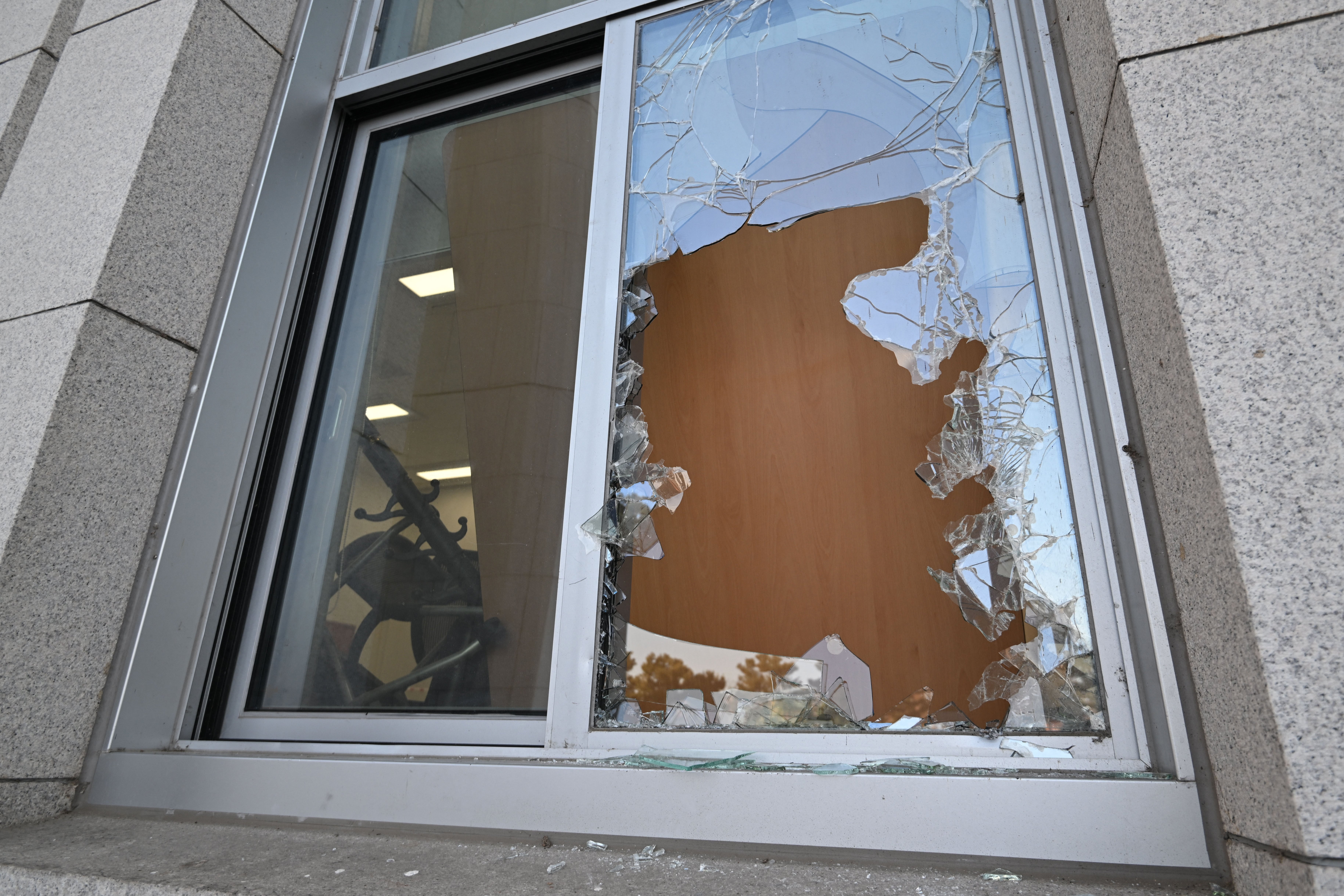 A window damaged by South Korean soldiers is seen at the National Assembly in Seoul on December 4, 2024, after South Korean president Yoon Suk Yeol lifted martial law just hours after he imposed it. Parliamentary staffers used sofas and fire extinguishers to block soldiers armed with assault rifles and night-vision goggles from entering South Korea's National Assembly to maintain martial law, CCTV footage released on December 4 showed