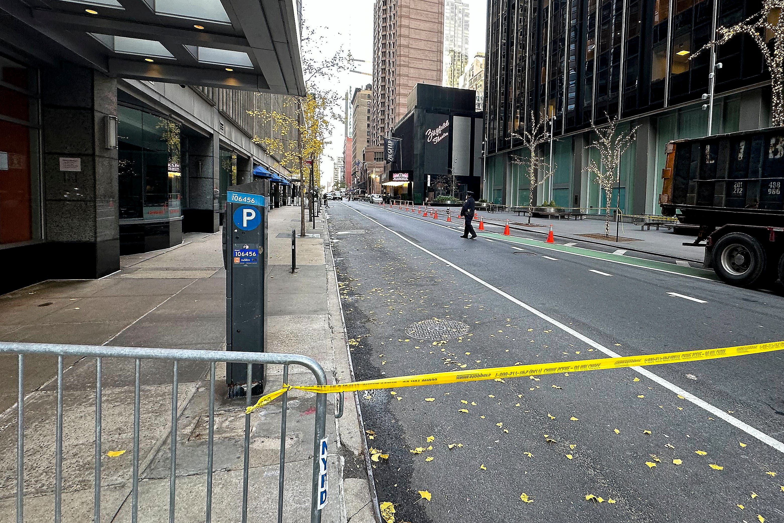 A New York police officer walks outside a hotel in midtown Manhattan where Brian Thompson, the chief executive of UnitedHealthcare, was fatally shot (Joe Frederick/AP)