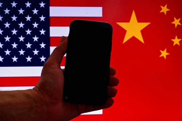 <p>An iPhone in front of a US flag and Chinese flag background in Washington, DC, on 16 March, 2023</p>