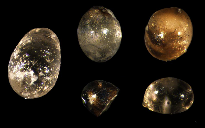 A microscopic image shows the silica droplets that were found in a rock core. The droplets form after rocks containing the compound are vaporized by an asteroid