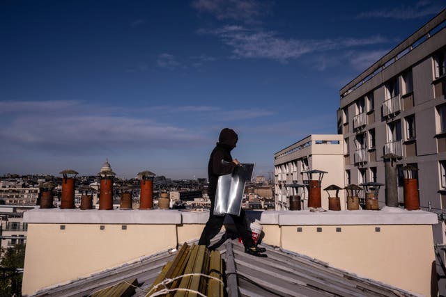 <p>A roofer carries zinc sheets of a building in Paris</p>