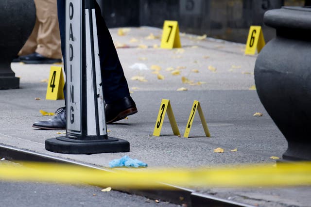 <p>Members of the New York police crime scene unit investigate bullets lying on the sidewalk at the scene outside the Hilton Hotel in midtown Manhattan where Brian Thompson, the CEO of UnitedHealthcare, was fatally shot</p>