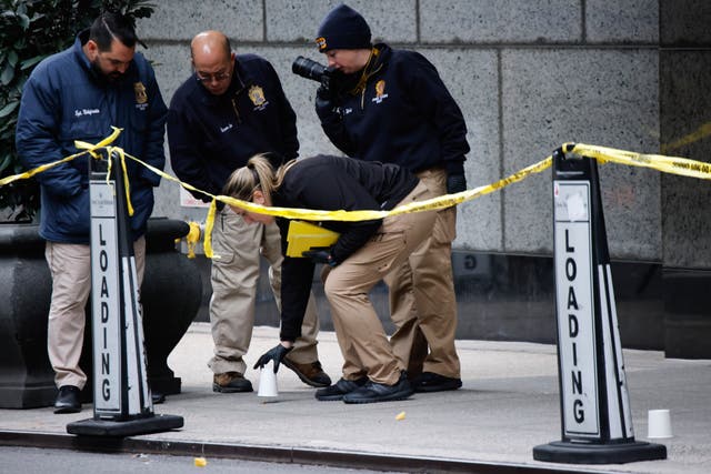 <p>Policía en el lugar del tiroteo. Se dice que los investigadores están buscando inscripciones en las balas usadas para matar a Brian Thompson</p>