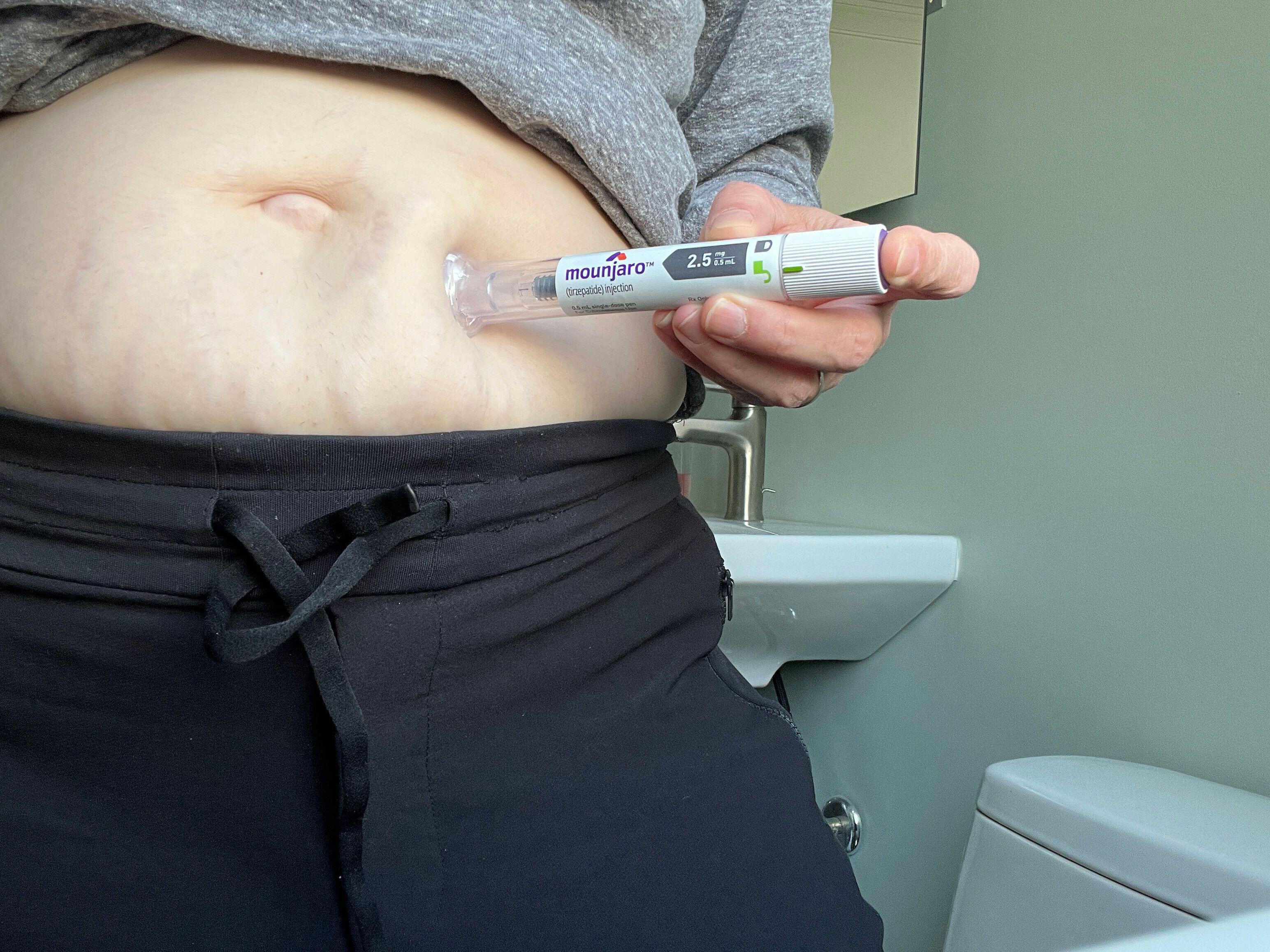 A Woman injecting herself in the abdomen with Mounjaro