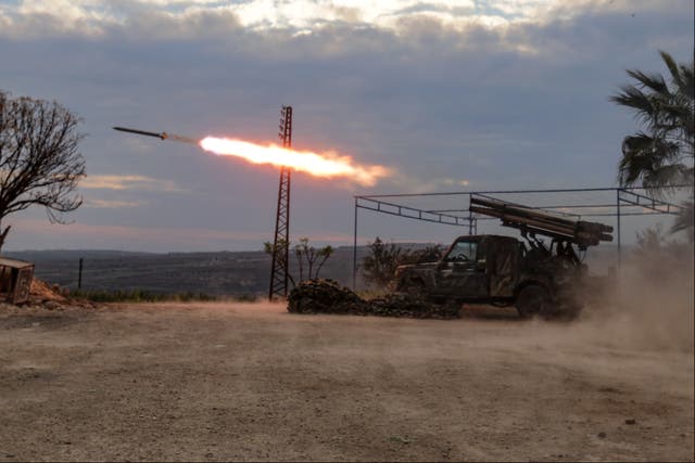 <p>An anti-government fighter covers his ears as a multi-barrel rocket launcher fires against Bashar al-Assad’s forces</p>