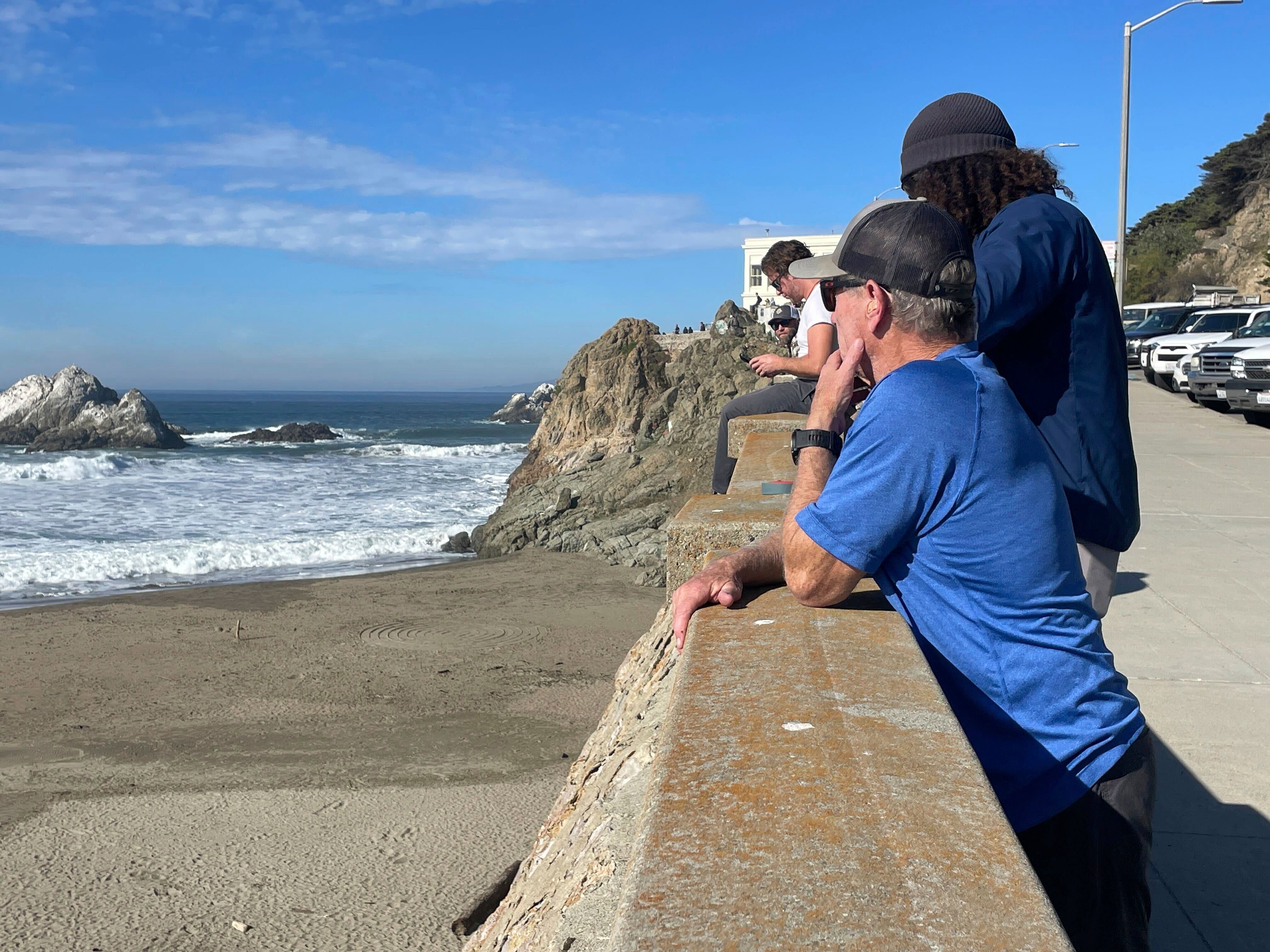 People watch the waves come in after an earthquake along San Francisco’s Ocean Beach in northern California. The Thursday quake was reported as a 7.0