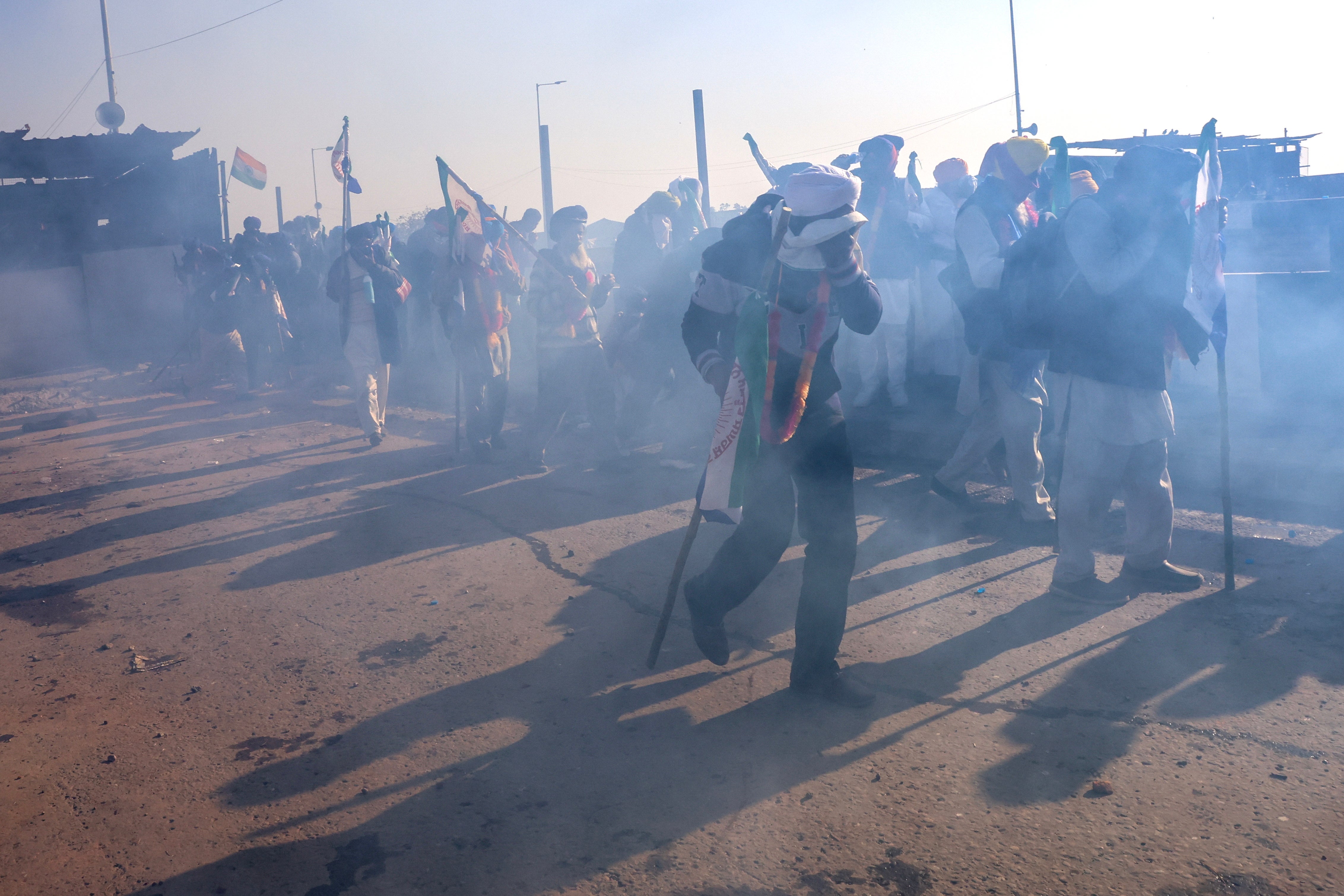 Indian farmers react to tear gas fired by Indian Police to prevent farmers moving towards Delhi during a ‘Delhi Chalo’ peaceful protest march