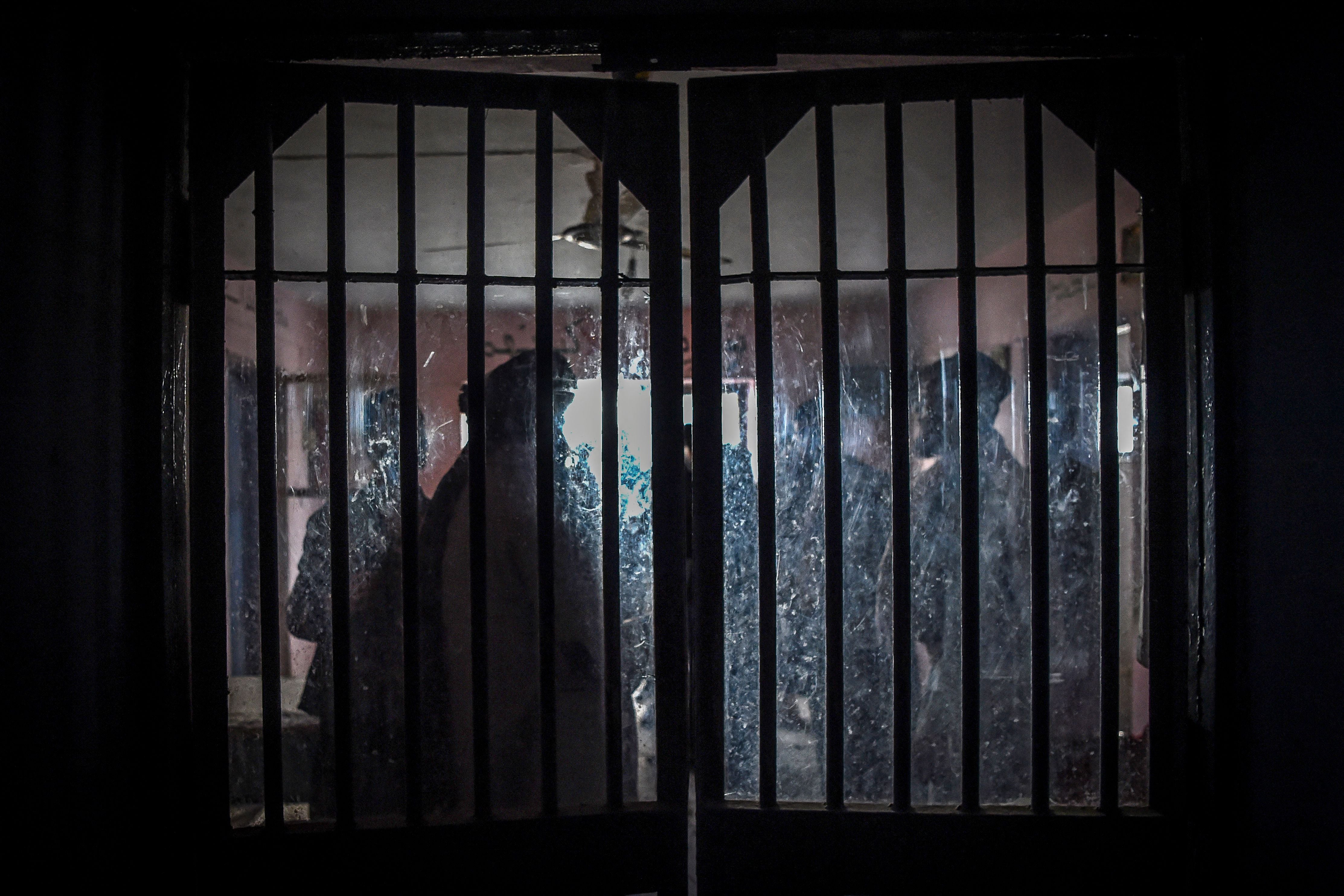 Taliban members are seen from a window as they inspect inside a prison cell at Pul-e-Charkhi prison, located on the outskirts of Kabul