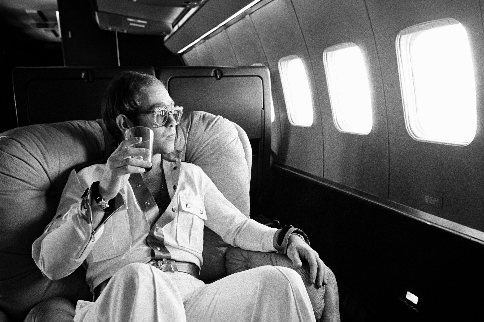 Elton John flies on his private Boeing 720 airplane known as ‘The Starship’ during his 1974 tour