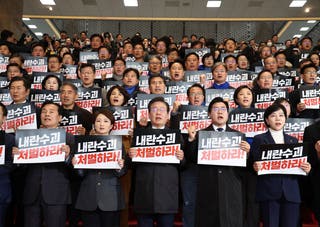 South Korea’s main opposition Democratic Party leader Lee Jae Myung, (bottom center), and his party members stage a rally to denounce President Yoon Suk Yeol’s apology over Tuesday’s martial law declaration at the National Assembly in Seoul, South Korea on Saturday. The signs read, “Punish.”