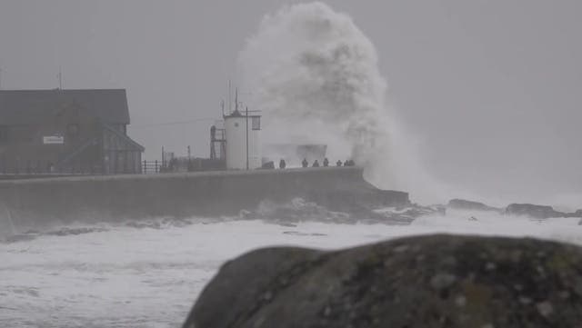 <p>Brave Storm Darragh watchers line harbour as 10-foot waves crash against wall.</p>