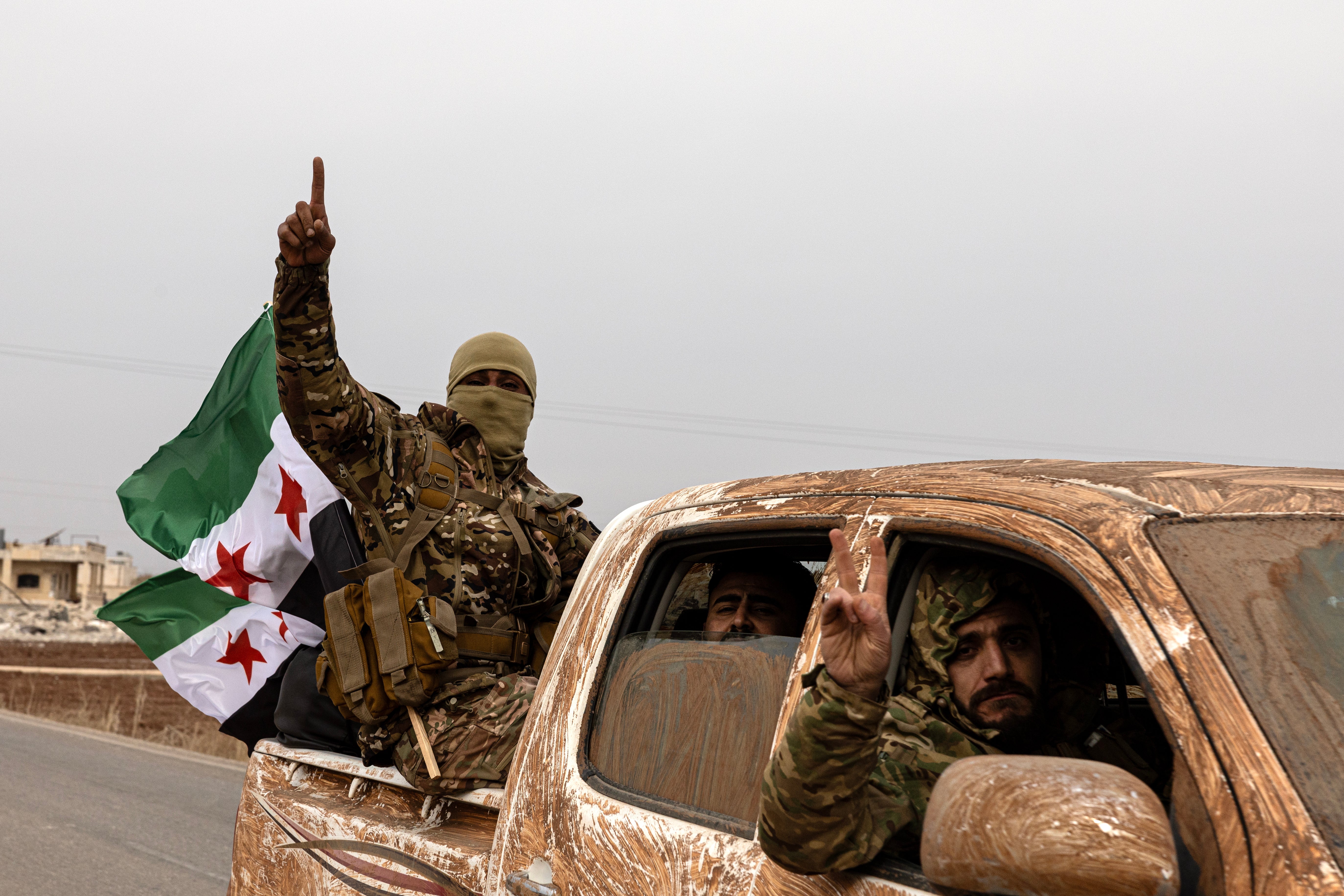 Syrian National Army (SNA) soldiers celebrate victory in Manbij on December 7, 2024 in Manbij, Syria