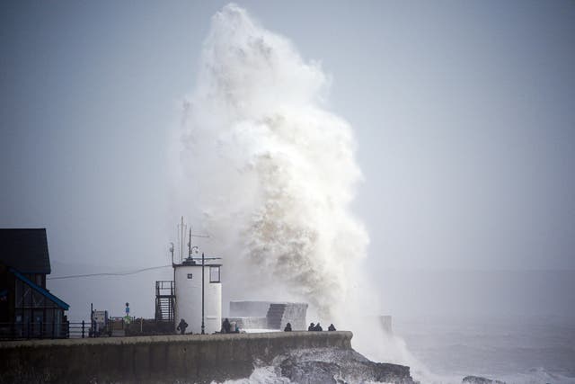 Waves crash over the seafront in Porthcawl in Wales as Storm Darragh hits (Ben Birchall/PA)