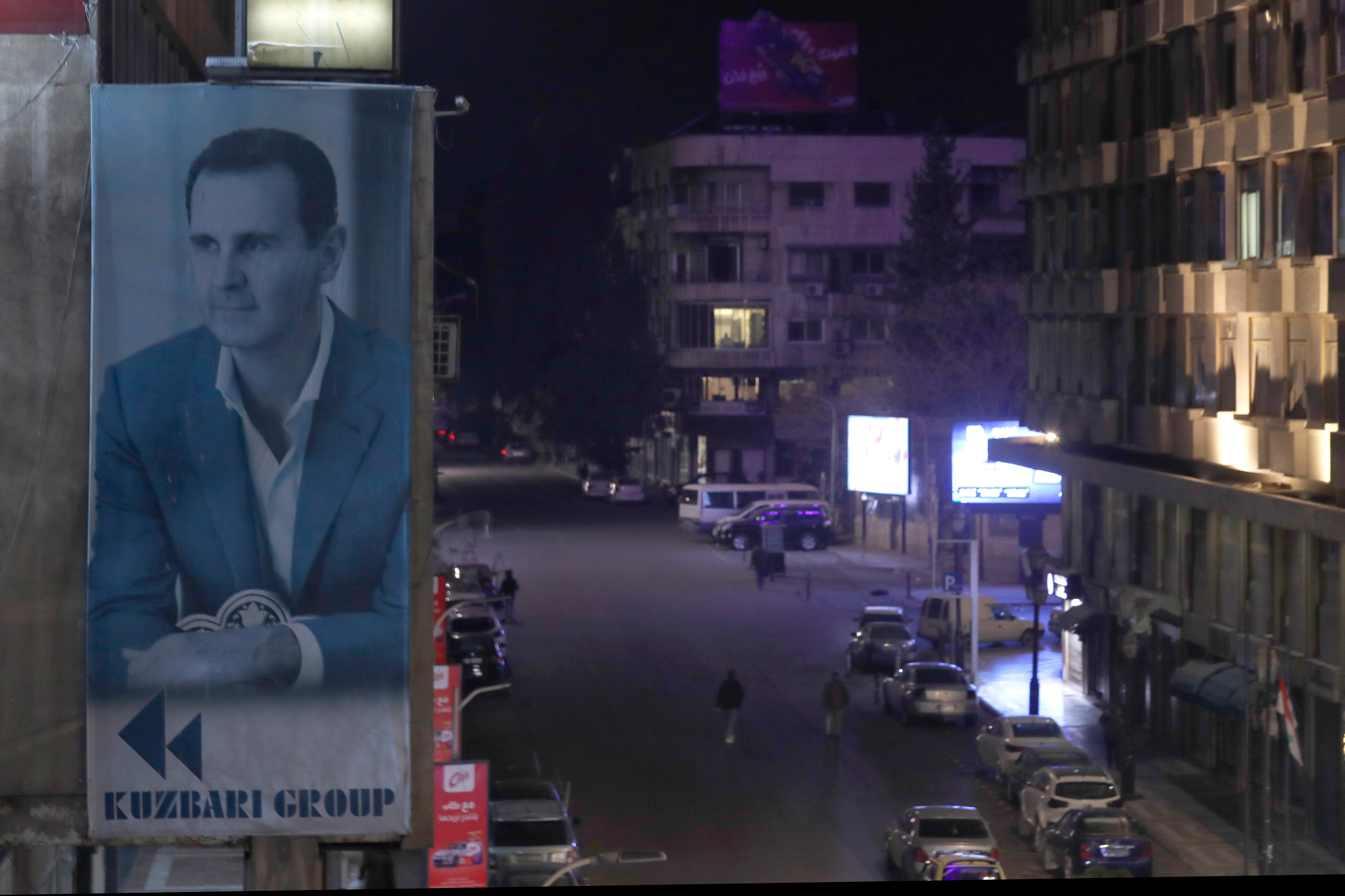 A giant banner of Syrian President Bashar Assad hangs on the facade of a building in Damascus