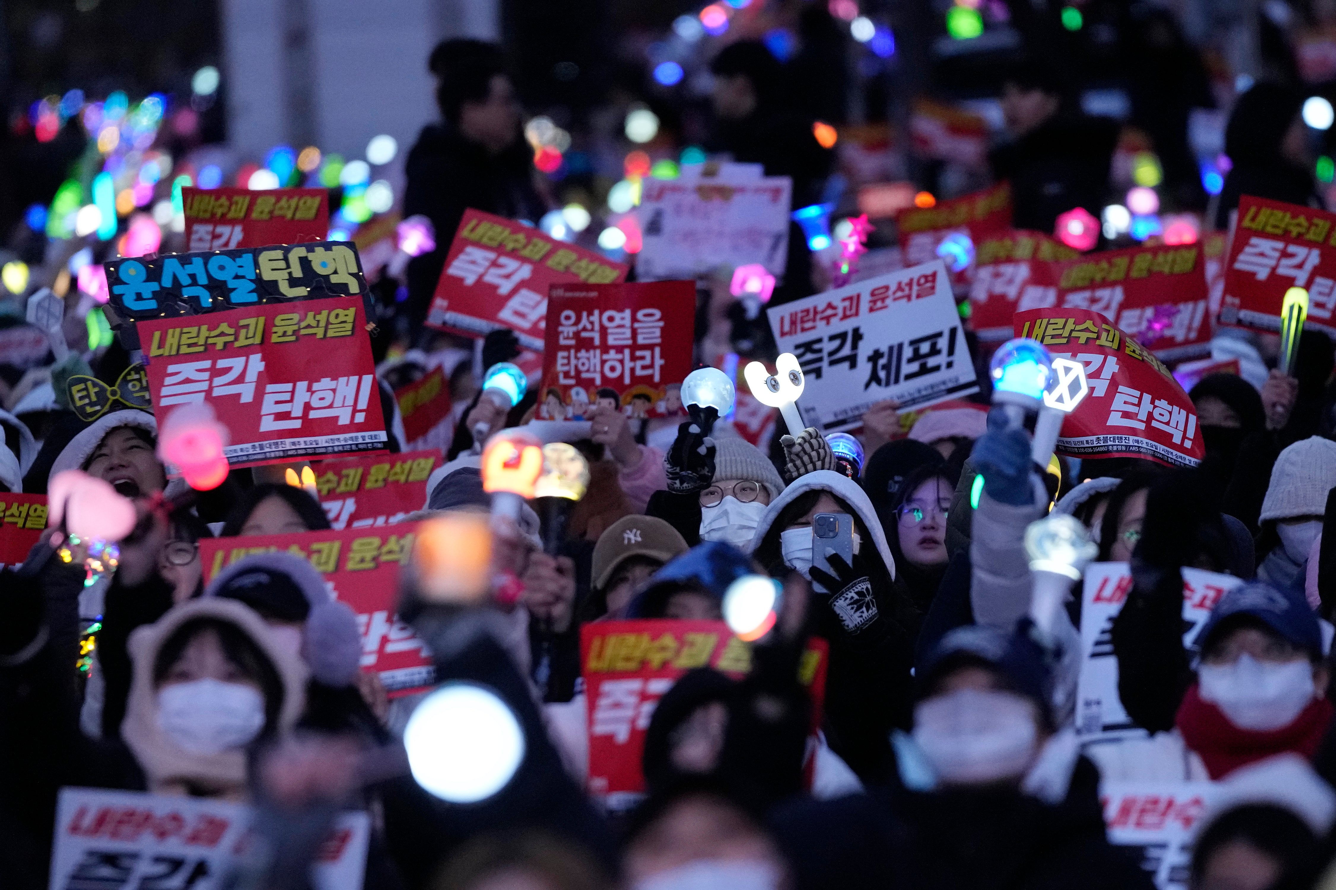 Participants attend a rally demanding South Korean President Yoon Suk Yeol’s impeachment outside the National Assembly in Seoul on Sunday. The signs read ‘Impeach Yoon Suk Yeol’