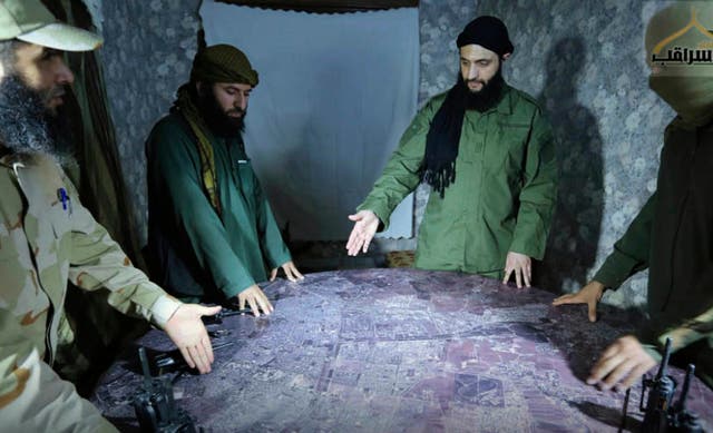 <p>Abu Mohammed al-Golani, the leader of Syria's al-Qaida affiliate, second from right, discussing battlefield details with commanders in Aleppo</p>