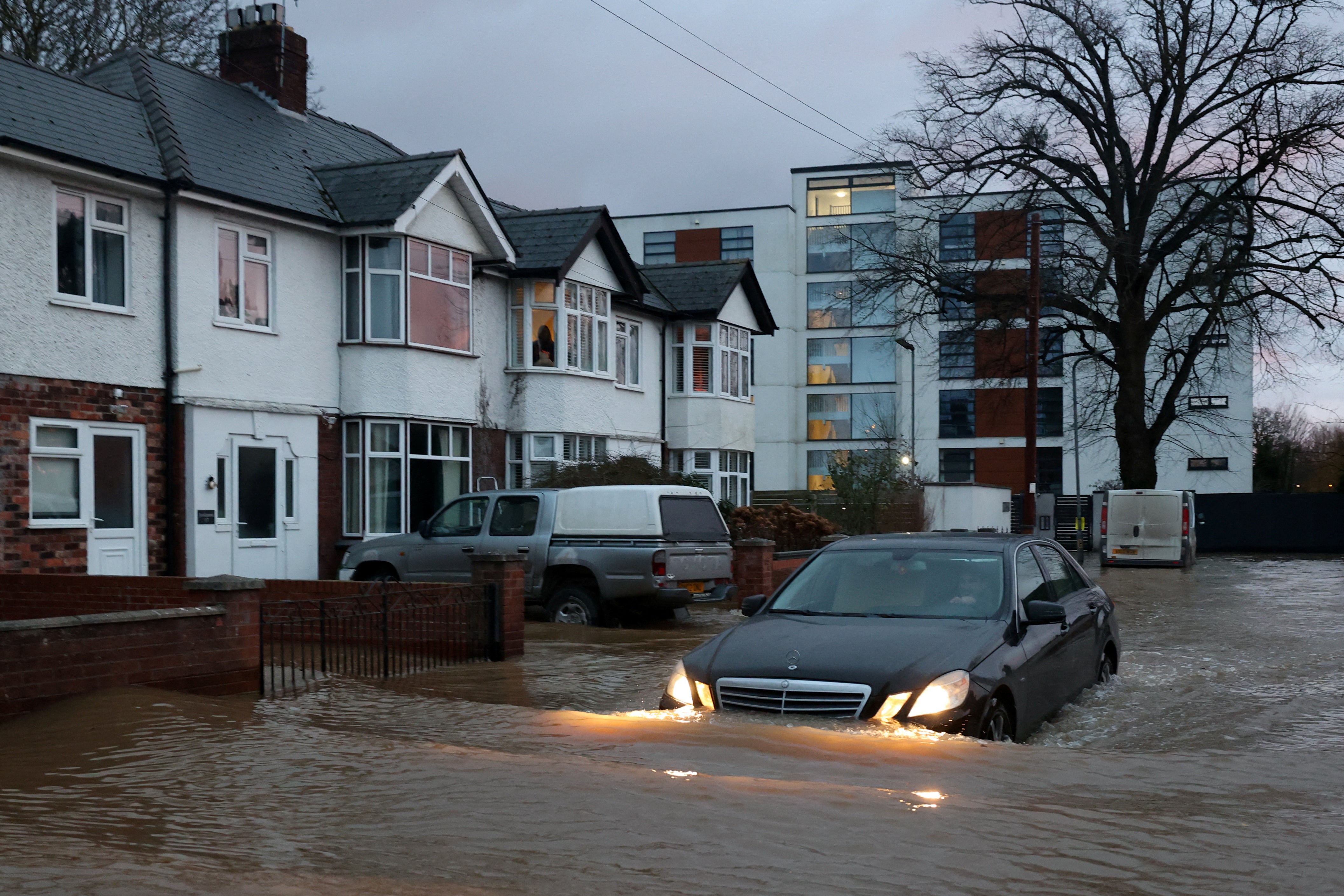 A person drives a car amid flooding after Storm Darragh hit the country, in Hereford, Britain