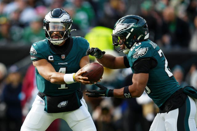 Philadelphia Eagles quarterback Jalen Hurts hands off to running back Saquon Barkley (Derik Hamilton/AP)