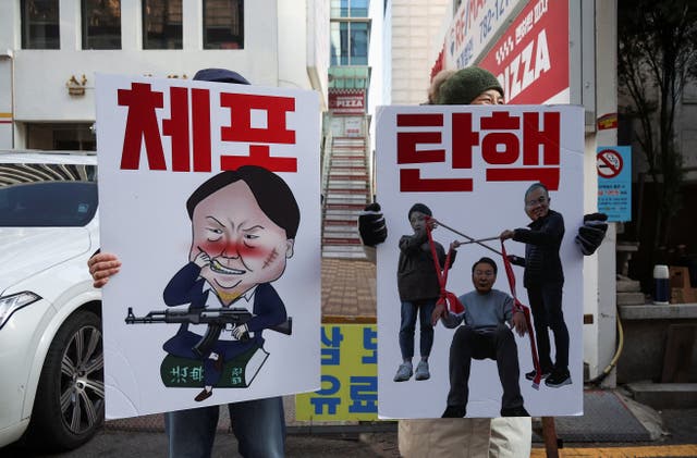 <p>People hold posters ahead of a rally calling for the impeachment of South Korean president Yoon Suk Yeol in Seoul</p>
