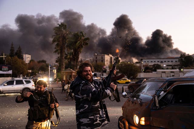 <p>People shoot in the air as they celebrate the fall of the Syrian government in Damascus, Syria, on Sunday</p>