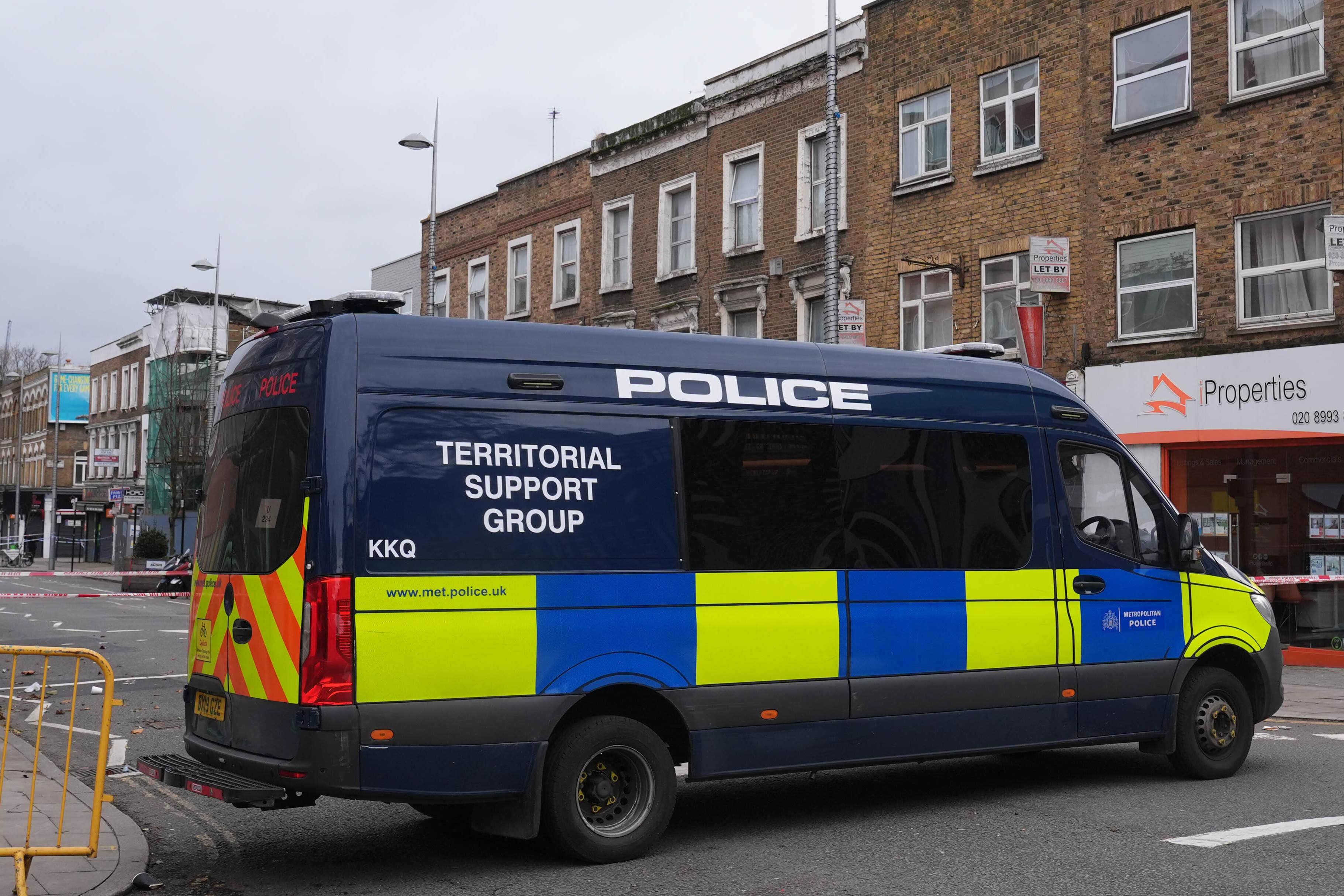 Police at the scene in Acton after a man was attacked by an armed gang after violence erupted near two barber shops (Lucy North/PA)