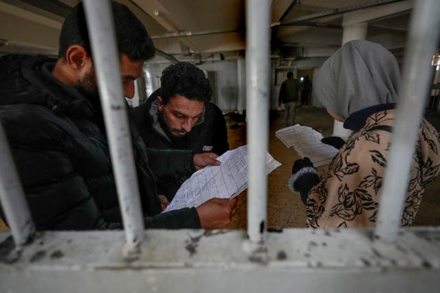 <p>People inspect documents they found in the infamous Saydnaya prison </p>