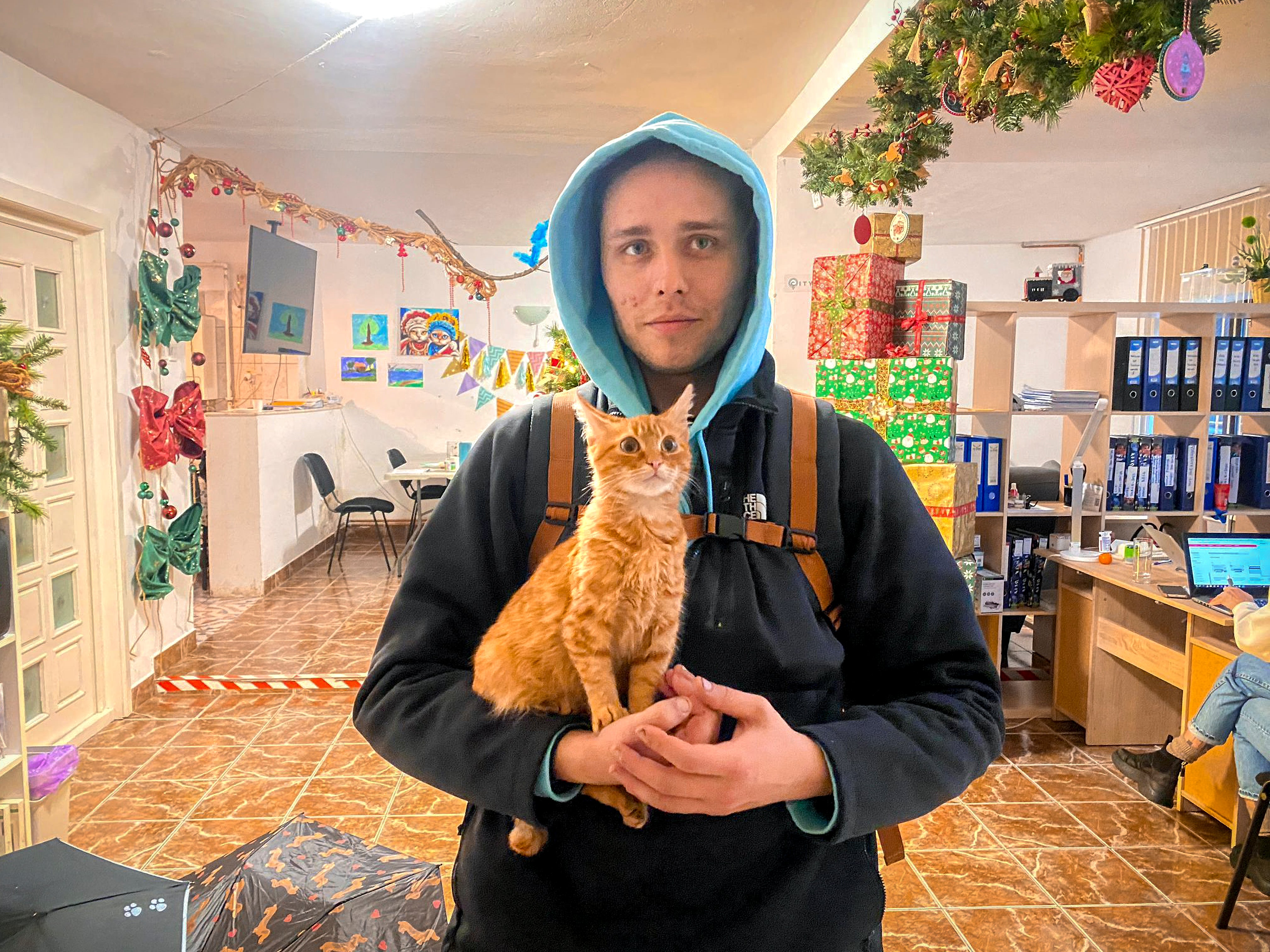 Vladislav Duda from Ukraine poses with his cat Peach in Baia Mare after being rescued three days ago from a deep mountain ravine in where he was stuck in a state of severe hypothermia