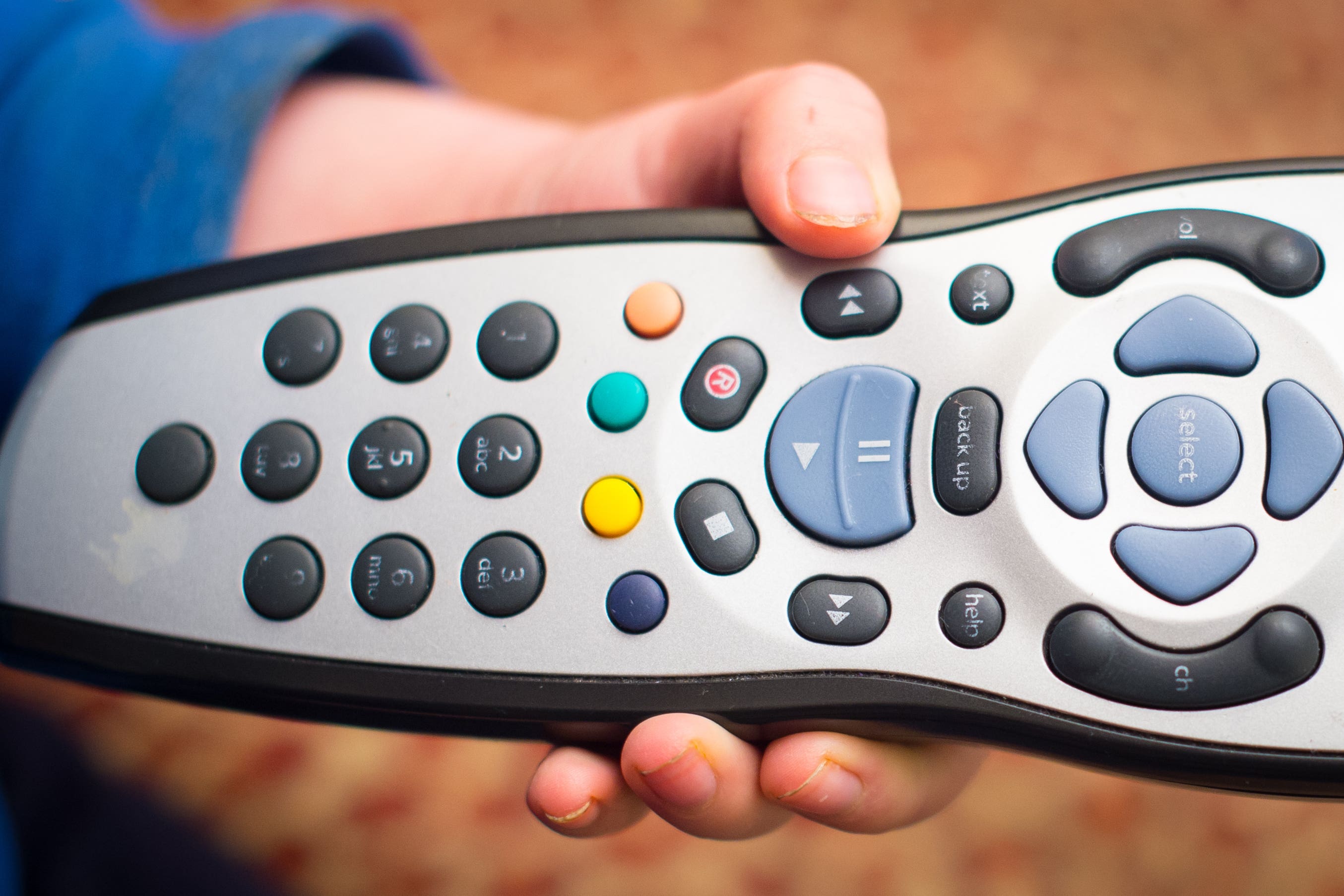 A child’s hand holds a television remote control (Dominic Lipinski/PA)