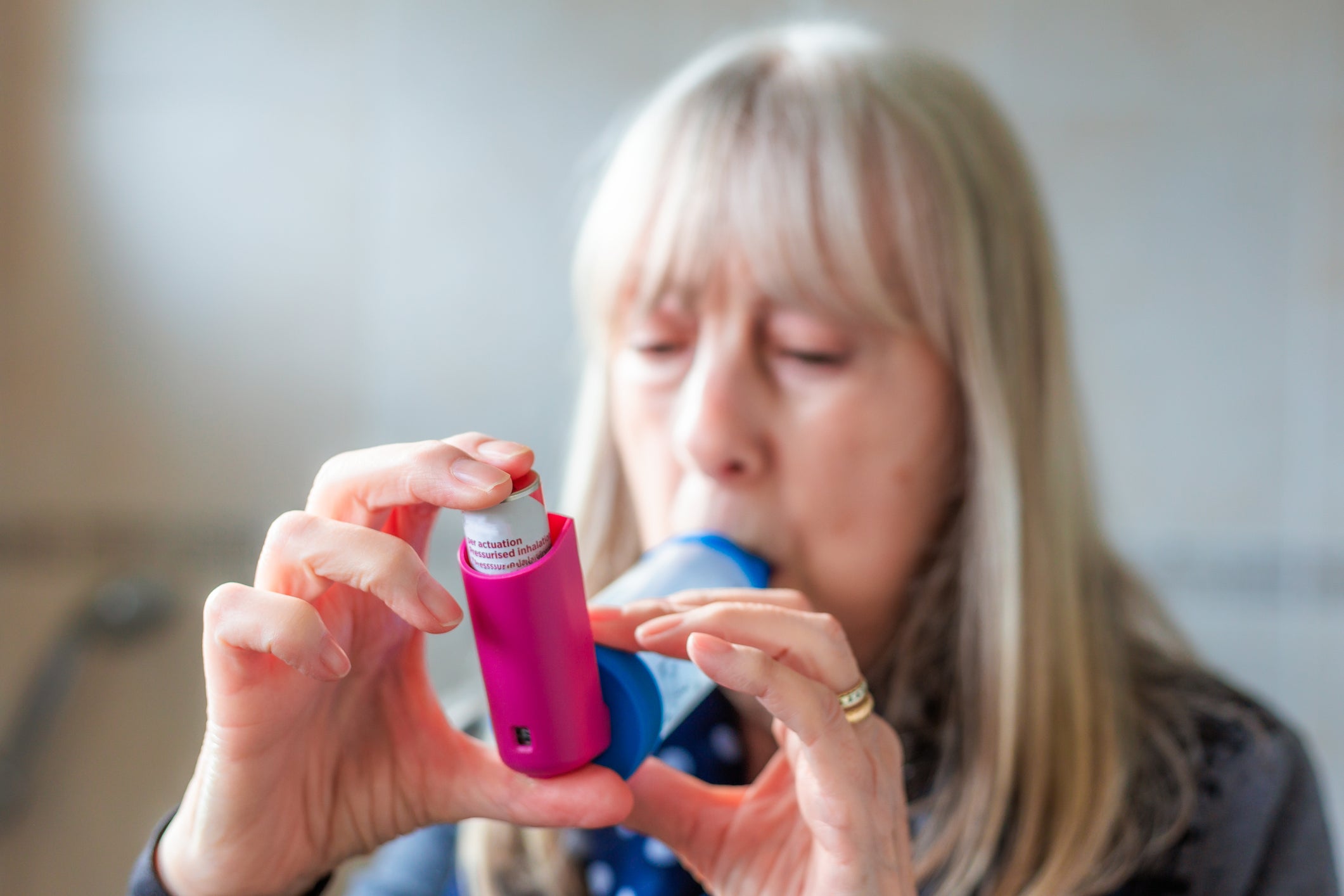 Uma mulher idosa usa seu inalador. Uma nova pesquisa descobriu que um em cada seis adultos nos EUA é impedido de tomar seus medicamentos para asma conforme prescritos devido ao seu custo.