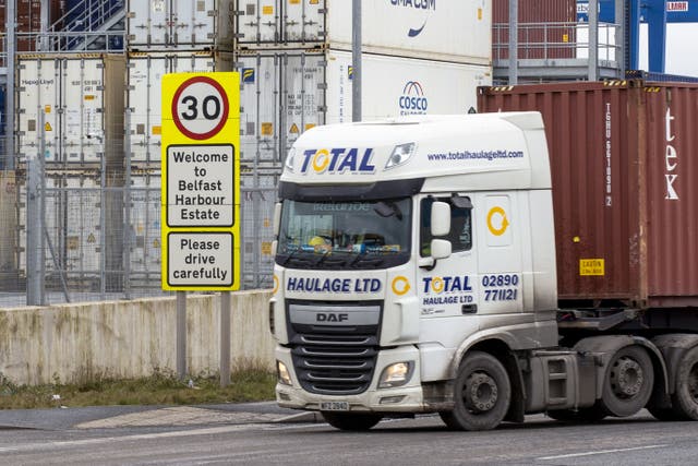 Haulage lorry drives passed a welcome sign to Belfast Harbour Estate in the Port of Belfast (PA)