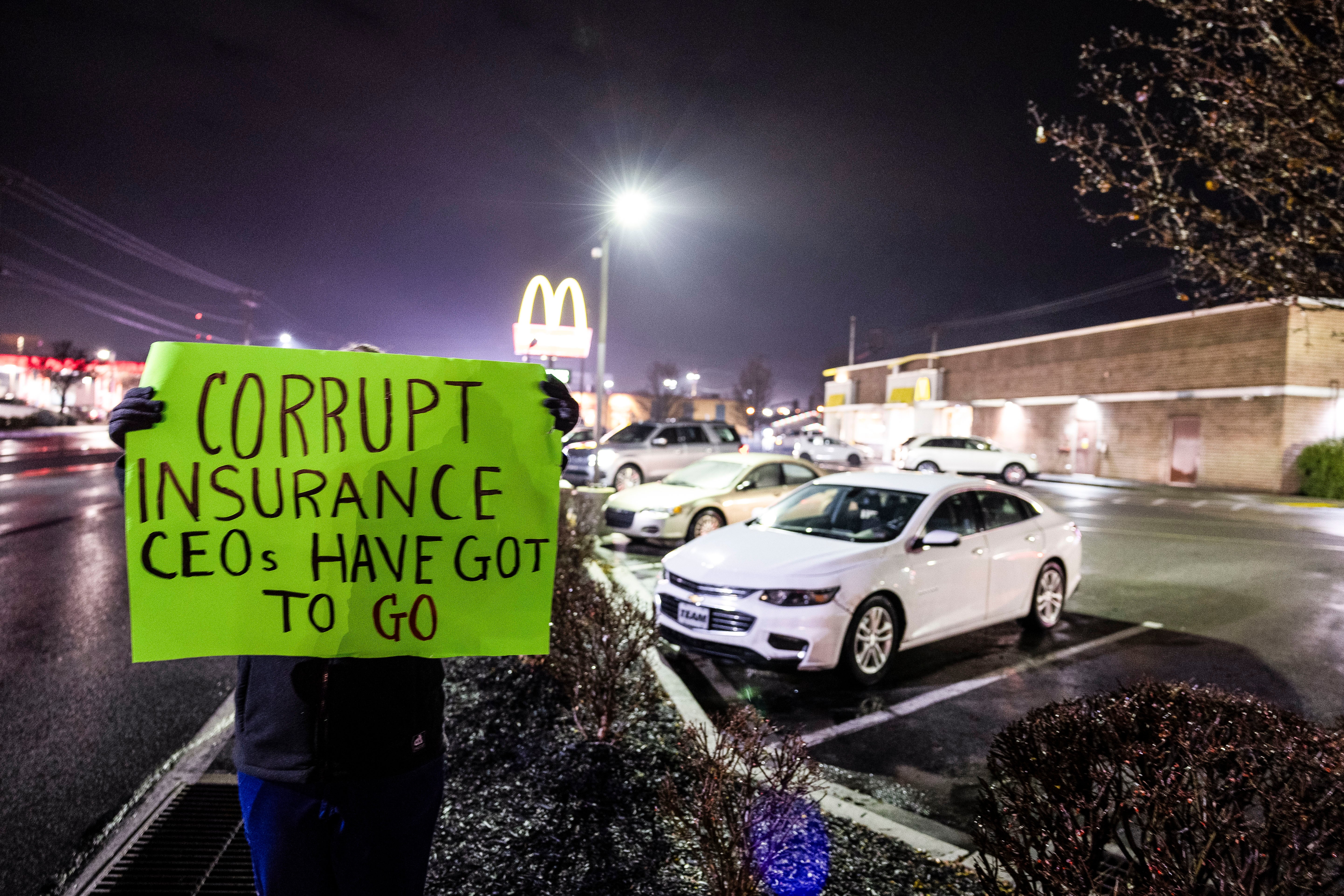 Seorang wanita, yang tidak ingin disebutkan namanya dan bekerja di industri perawatan kesehatan, memegang tanda protes di luar restoran McDonald's tempat polisi Altoona menangkap Luigi Mangione, tersangka penembakan hingga kematian CEO UnitedHealthcare Brian Thompson.