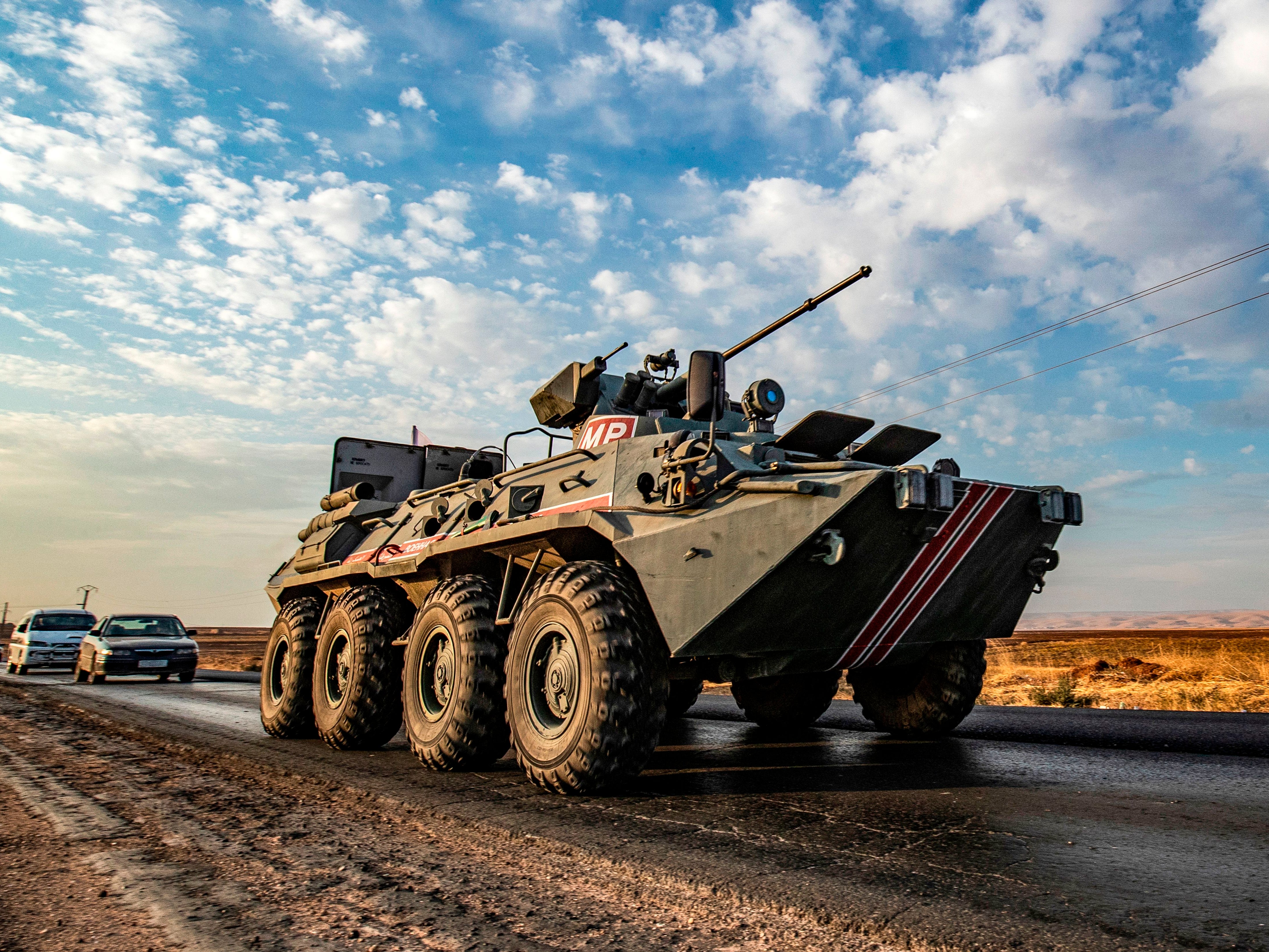 A Russian tank drives along a road in the Syrian town of Amuda