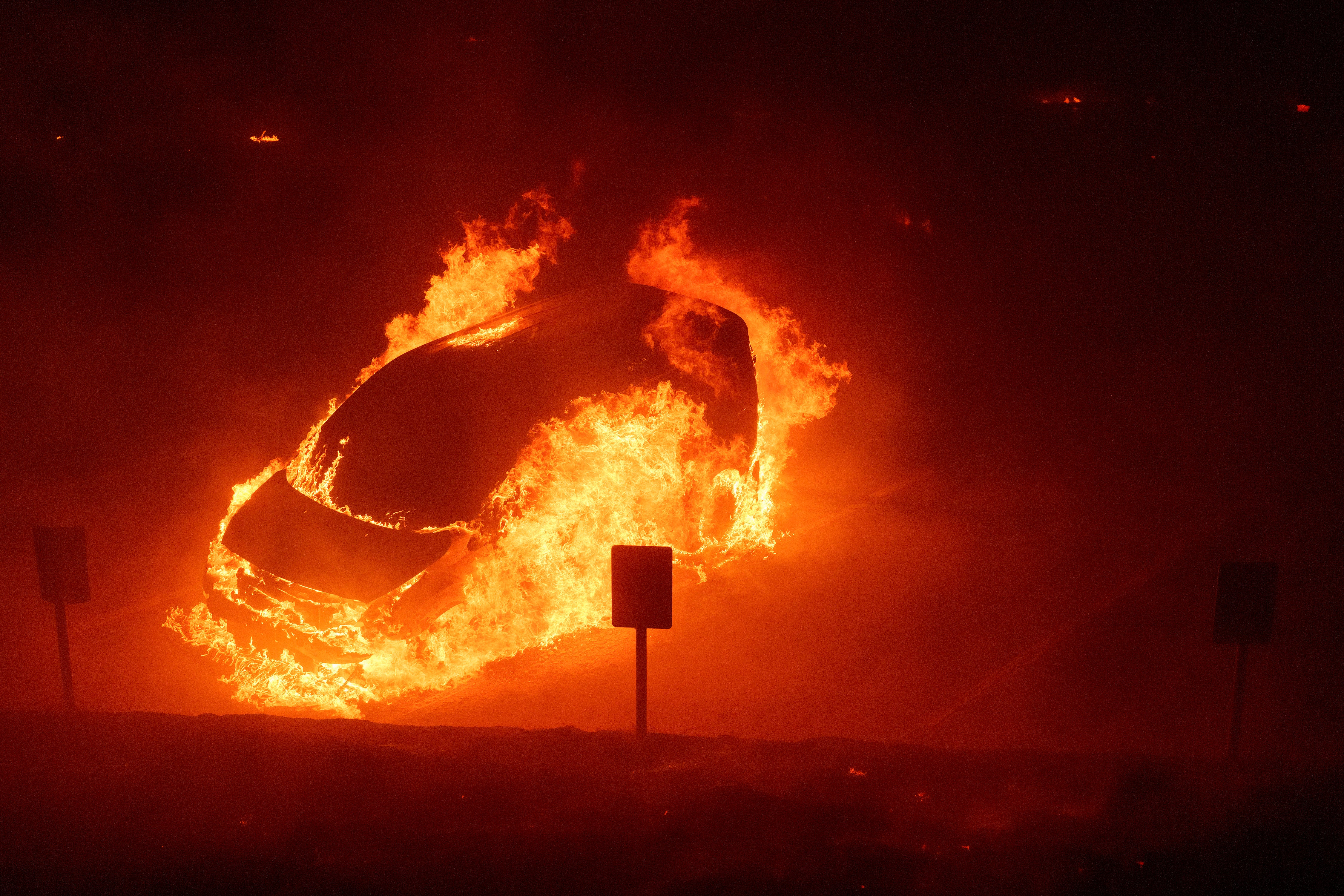 A vehicle burns Tuesday during the Franklin Fire on the campus of Pepperdine University in Malibu, California. A shelter in place order for the campus was lifted