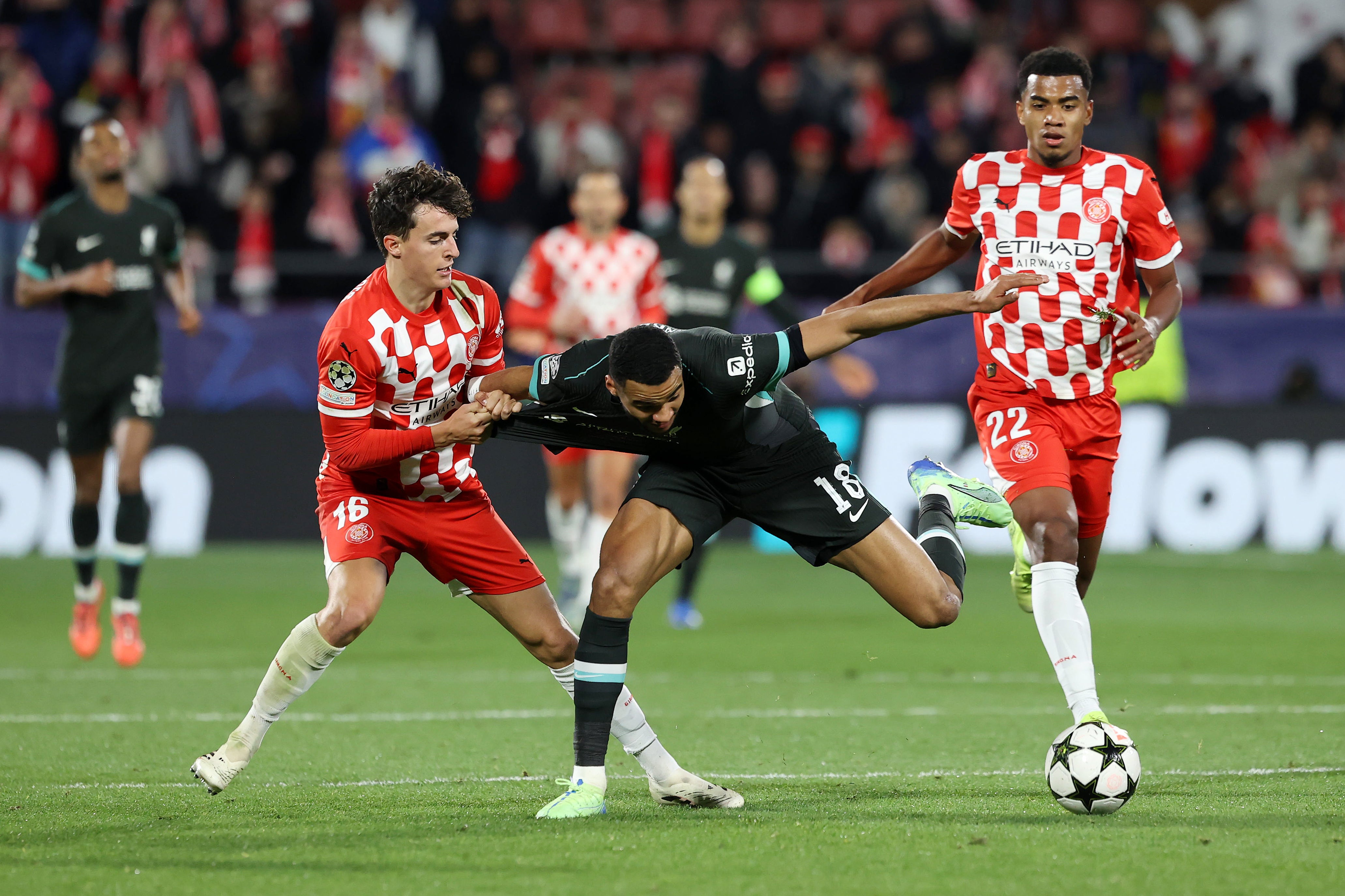 Liverpool's Cody Gakpo (centre) is tackled by Girona's Alejandro Frances (left)