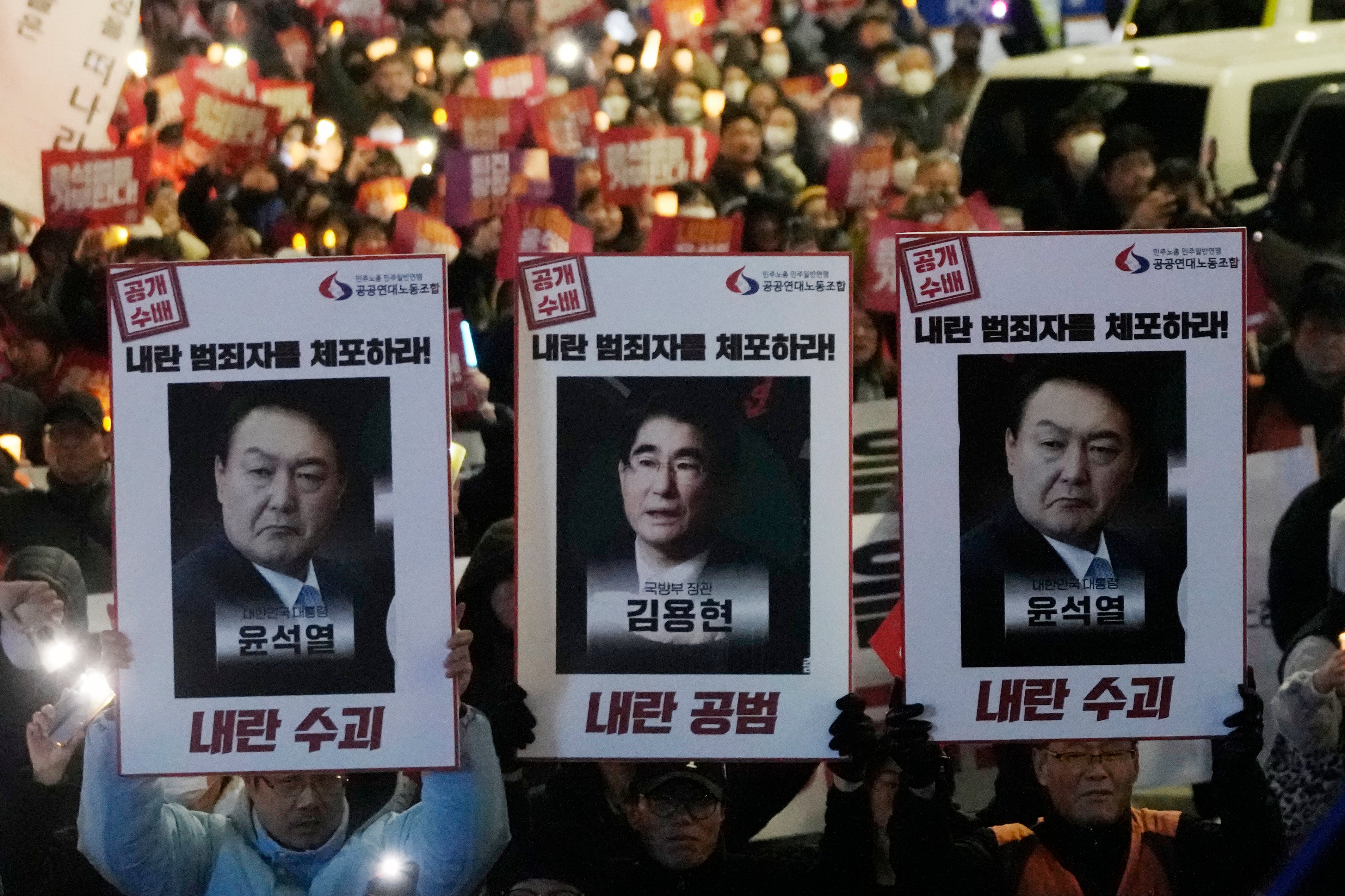 Protesters with images of South Korean President Yoon Suk Yeol and former South Korea Defense Minister Kim Yong Hyun, center, march to the presidential office after a candlelight vigil against President Yoon in Seoul, South Korea, on 5 Dec 2024