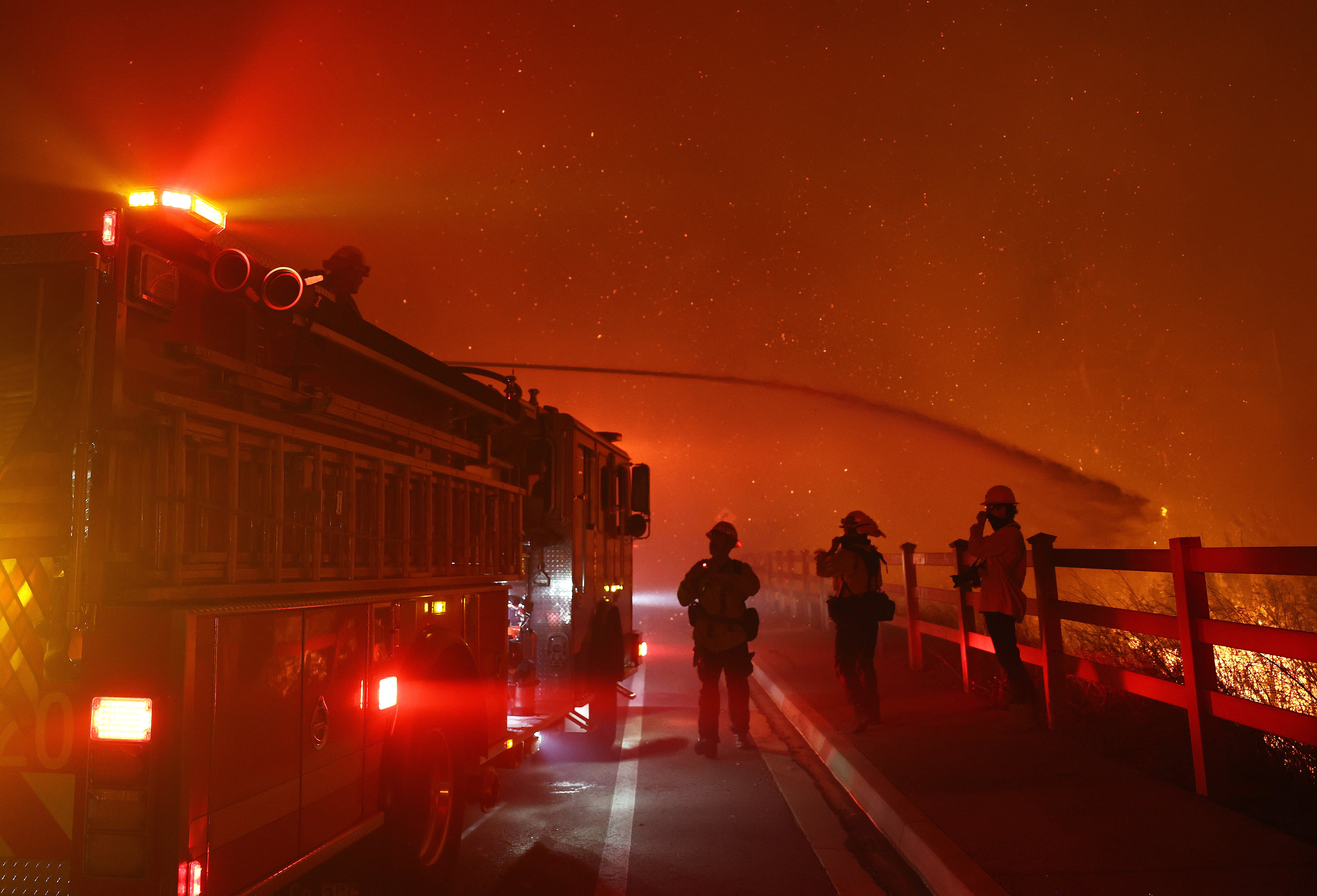 A firefighter sprays water as the Franklin Fire burns in Malibu, California