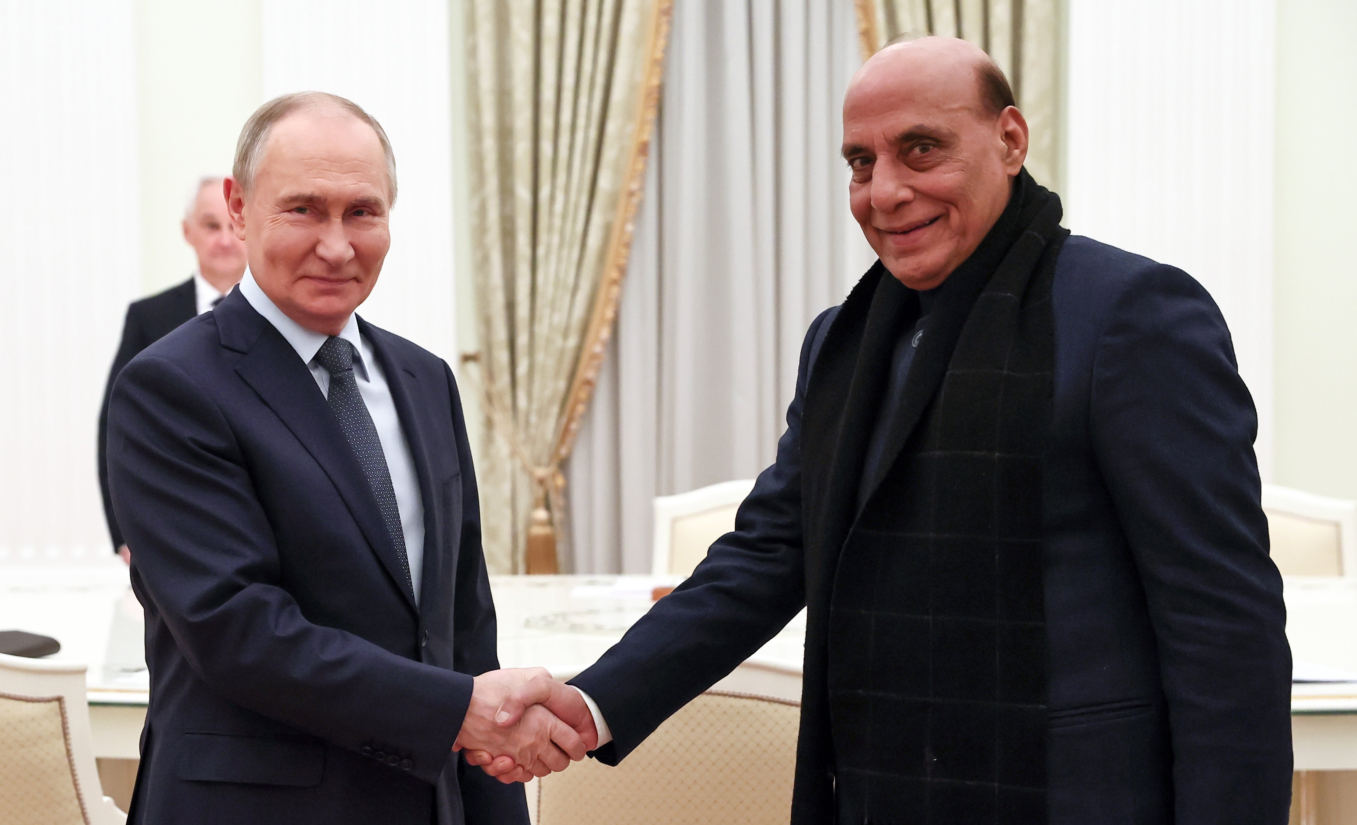 Russian President Vladimir Putin (L) and Indian Defence Minister Rajnath Singh shake hands. Russia is India’s top destination for for crude oil imports.