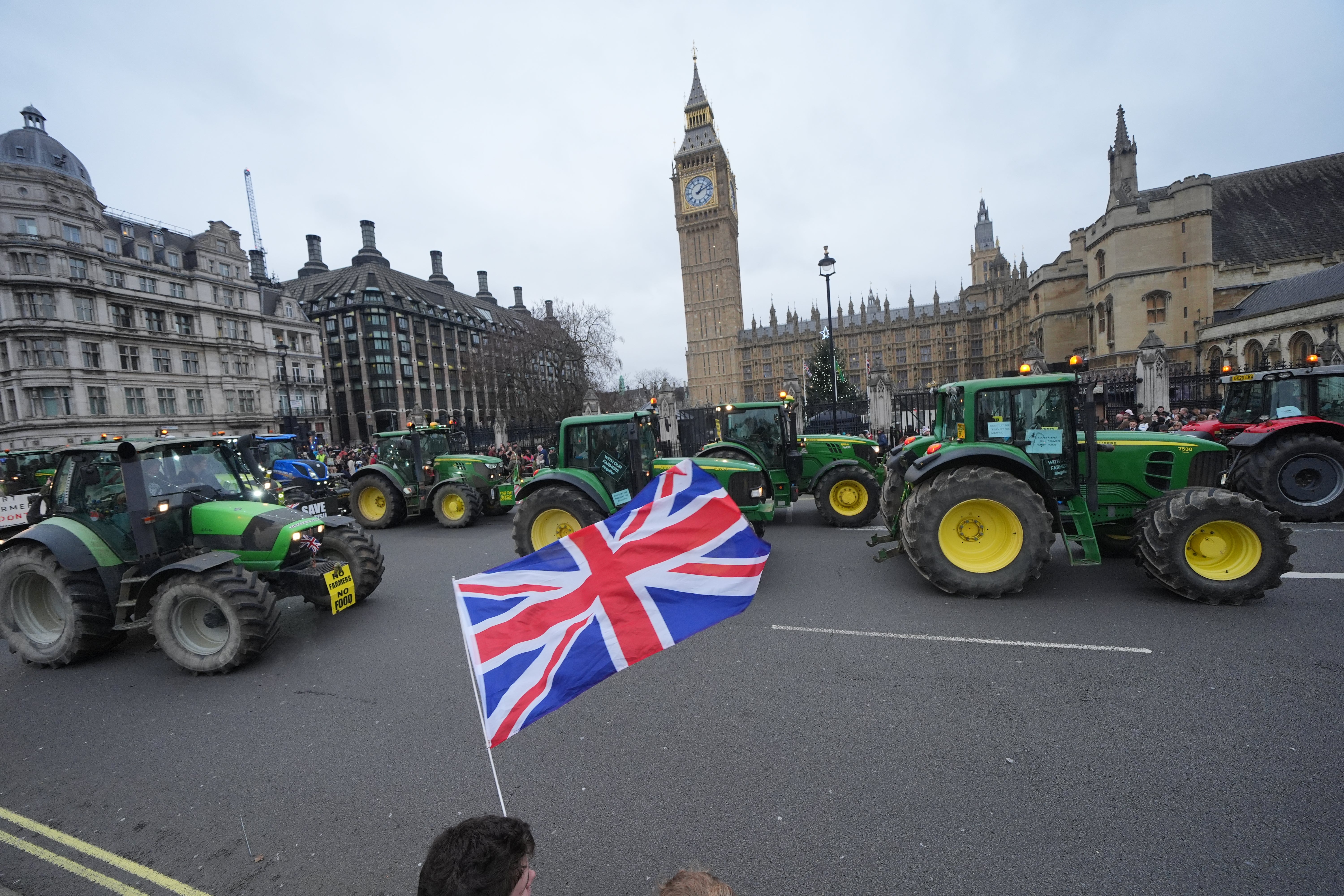 A union jack flag is flown as tractors pass the Houses of Parliament, where Sir Keir Starmer remained resolute on plans to bring in inheritance tax