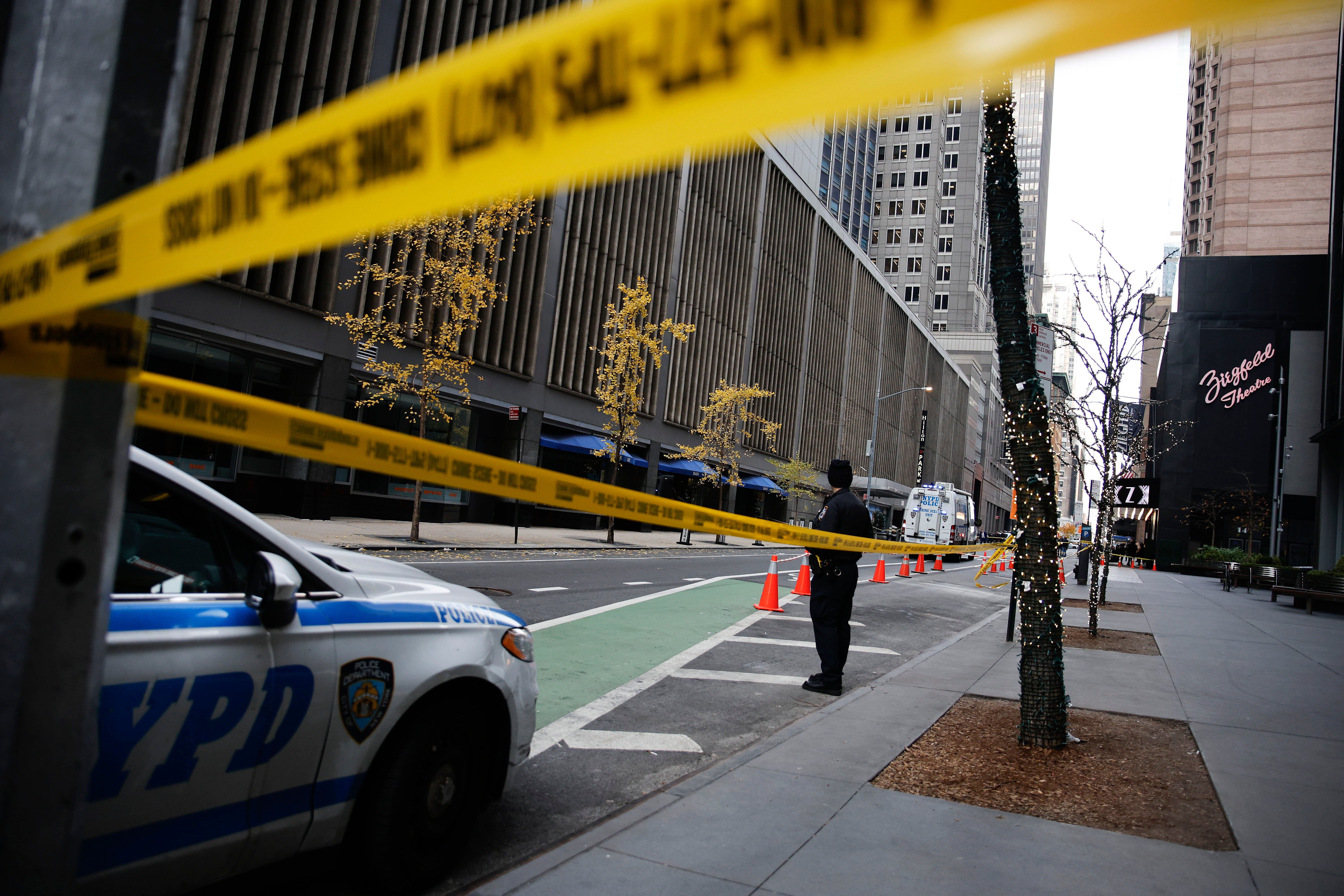 A New York police officer stands on 54th Street outside the Hilton Hotel in midtown Manhattan where Brian Thompson, the CEO of UnitedHealthcare, was fatally shot Wednesday, Wednesday, Dec. 4, 2024, in New York. (AP Photo/Stefan Jeremiah)