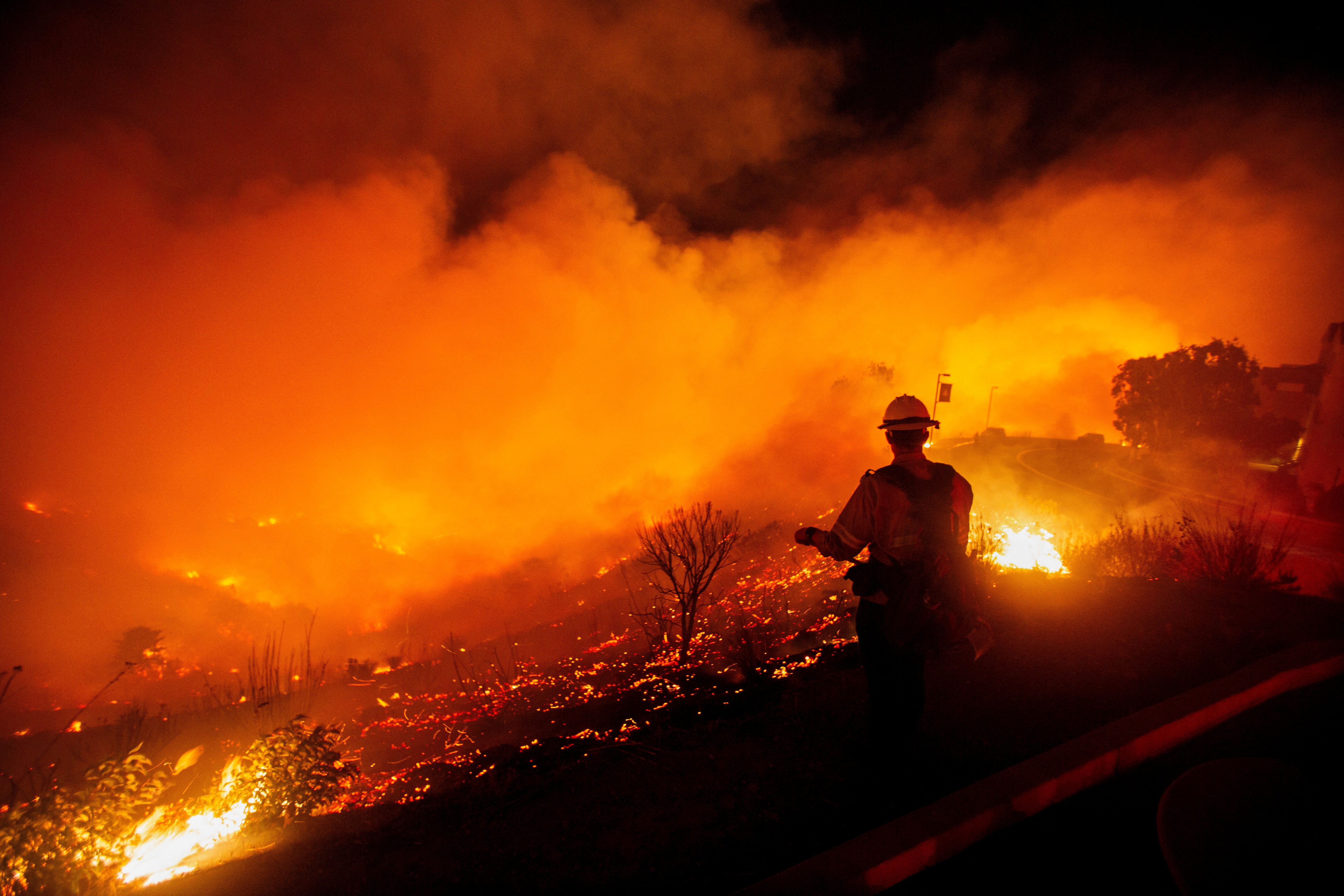 A firefighter watches as the Franklin Fire burns on Tuesday in Malibu, California. Hundreds of personnel were assigned to the incident