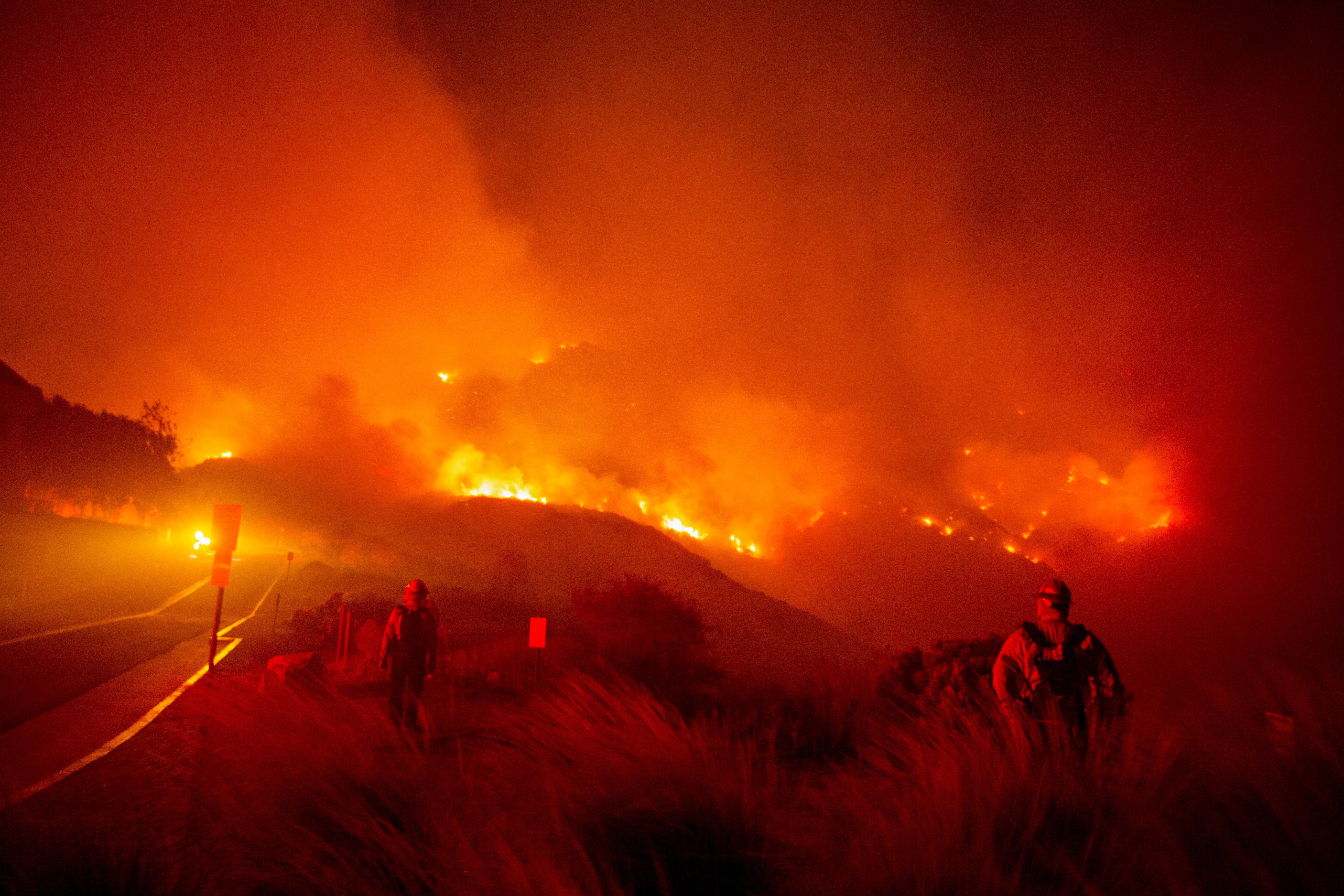 Firefighters watch as the Franklin Fire burns on Tuesday in Malibu, California. No injuries or deaths have been reported