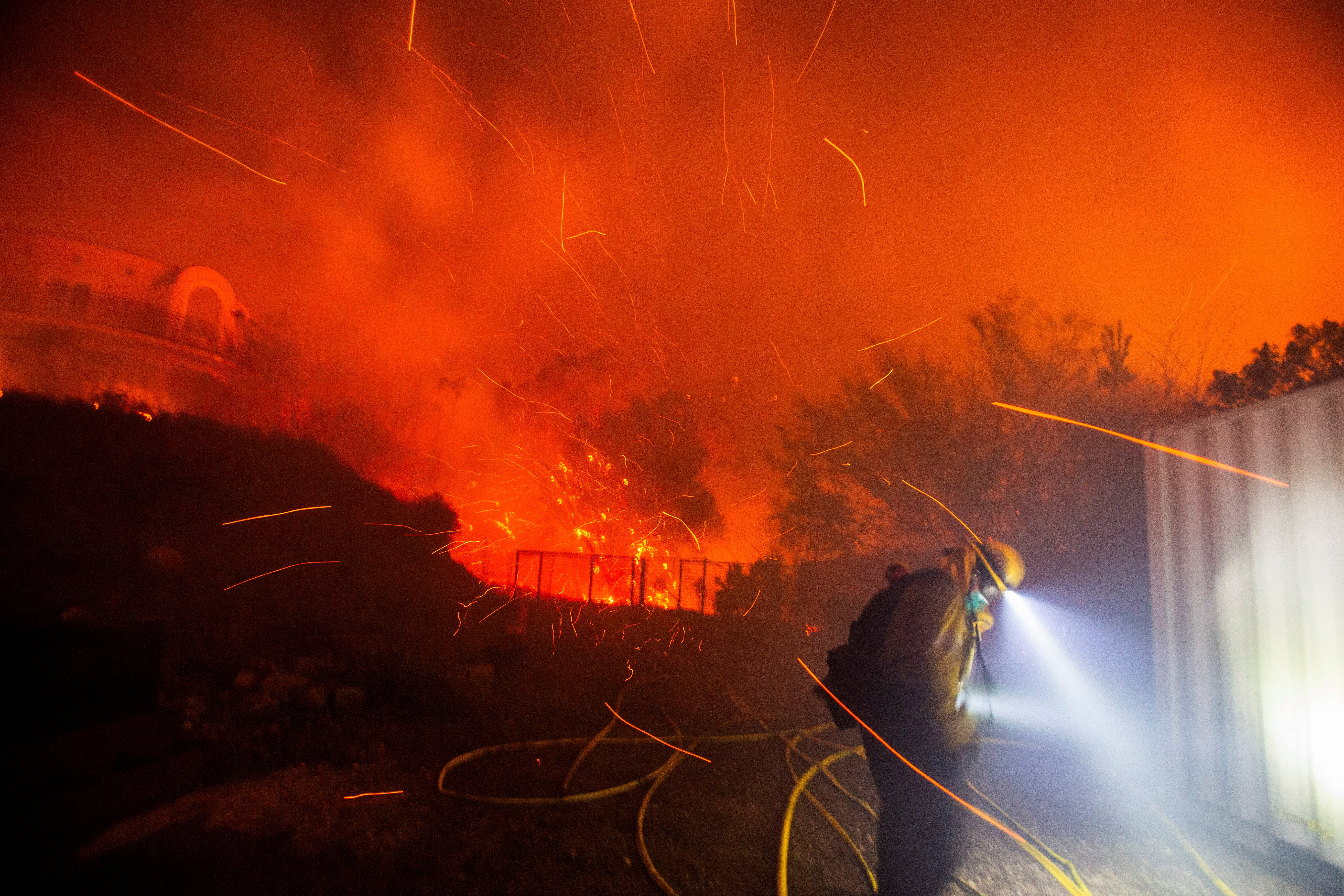 A firefighter works in windy conditions Tuesday as the Franklin Fire burns in Malibu, California. The wildfire is fueled by the Santa Ana winds