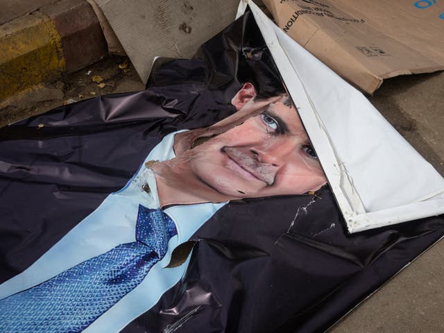 <p>A destroyed poster of former President of Syria Bashar al-Assad</p>