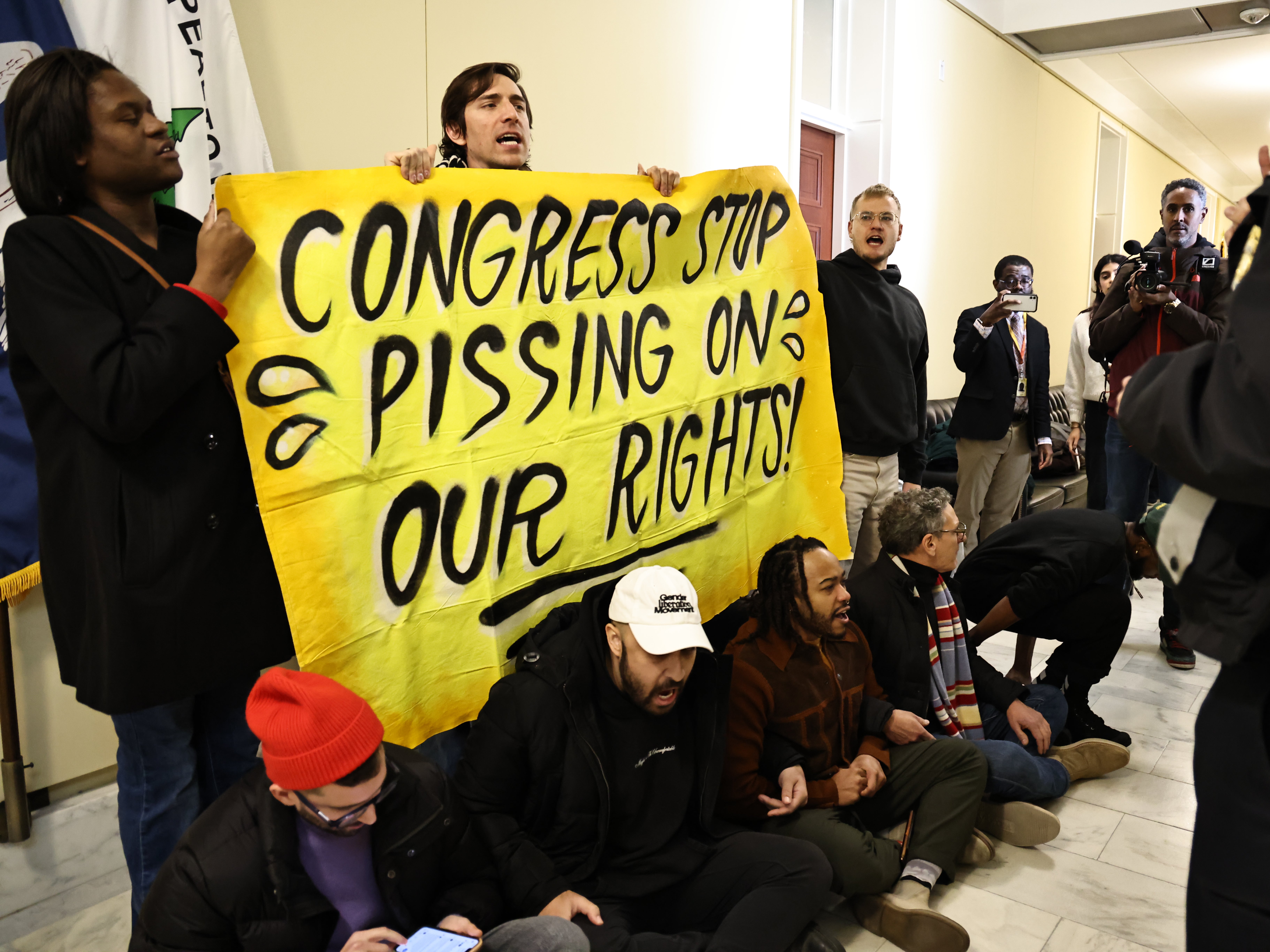 Pengunjuk rasa hak trans melakukan protes di luar kamar mandi wanita di US Capitol pada Kamis, 5 Desember 2024.