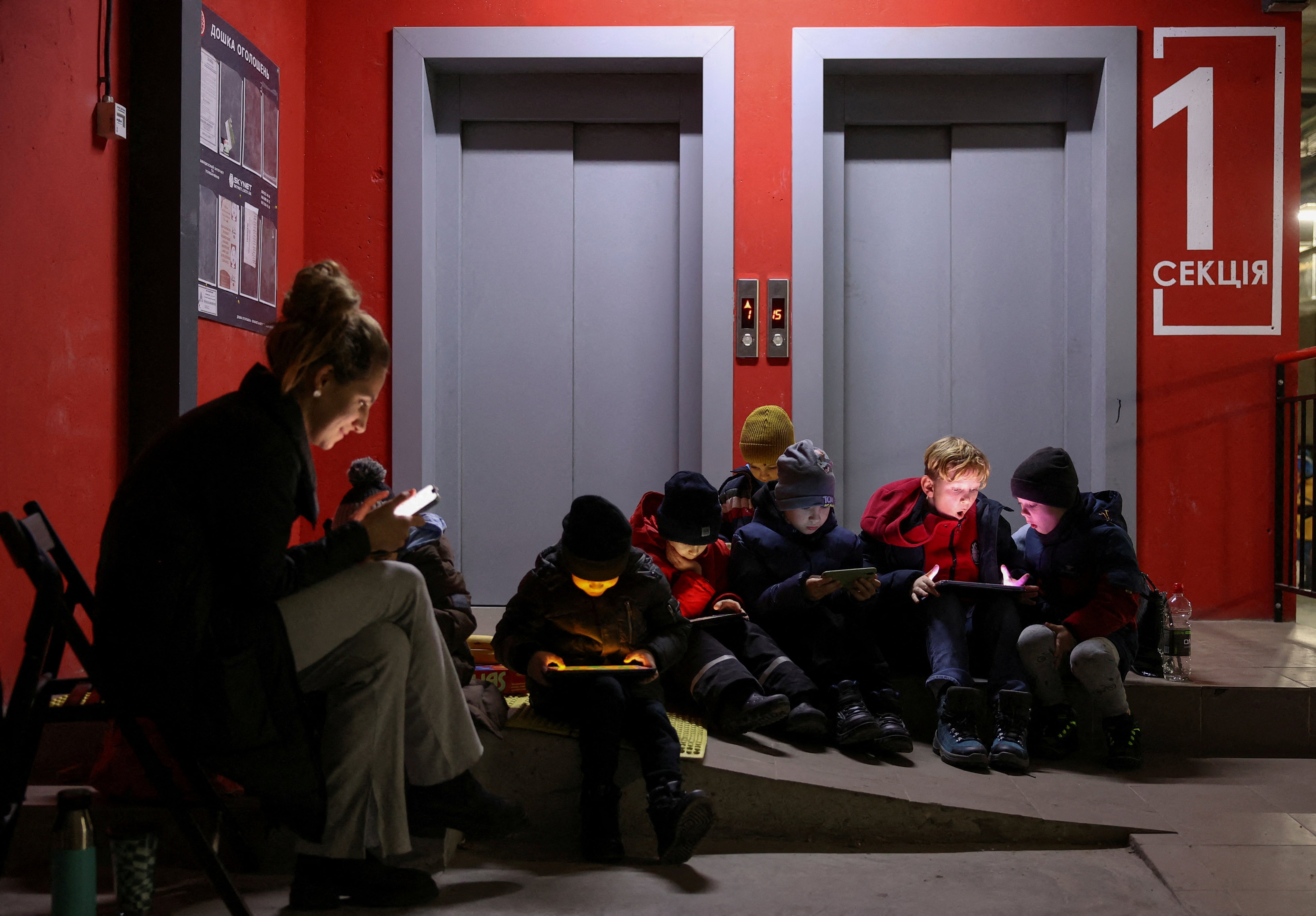 People take a shelter inside an underground parking of an apartment building during a massive Russian missile attack across a country, in Lviv, Ukraine