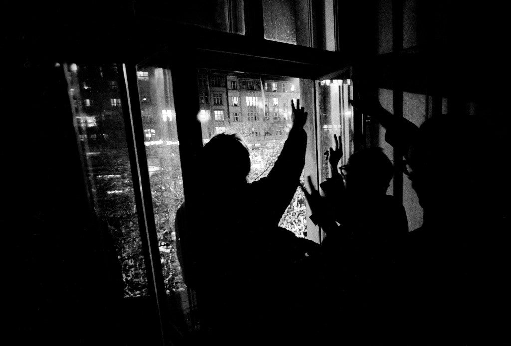 Supporters motion ‘V’ signs from a nearby window as Dubcek makes a powerful appearance at a protest in Prague